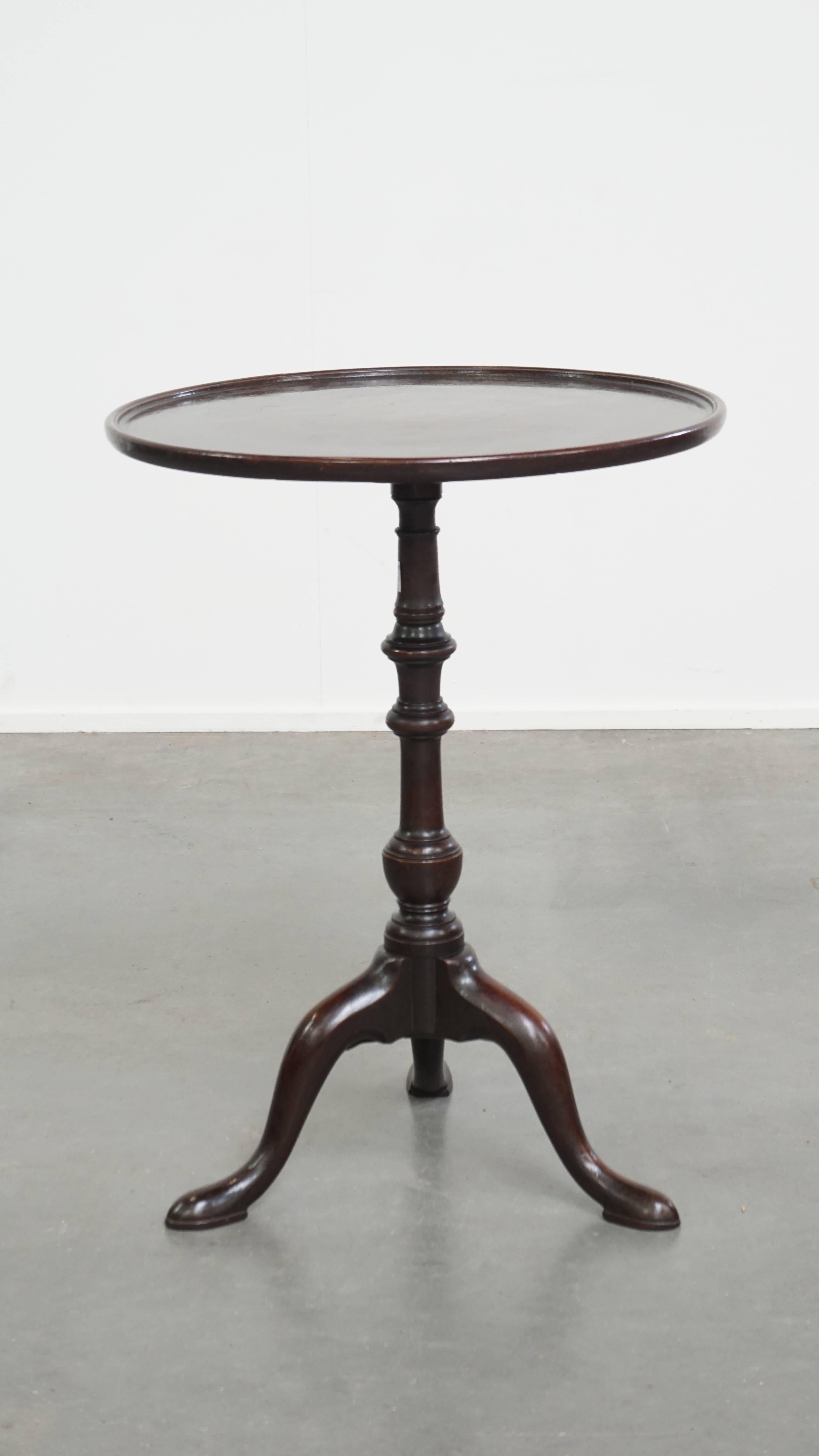 Aquí se ofrece esta encantadora mesa auxiliar o de vino antigua inglesa con tablero de una sola pieza, de principios del siglo XIX. Esta elegante mesa redonda con tablero basculante tiene un aspecto intemporal y una cálida pátina, lo que la