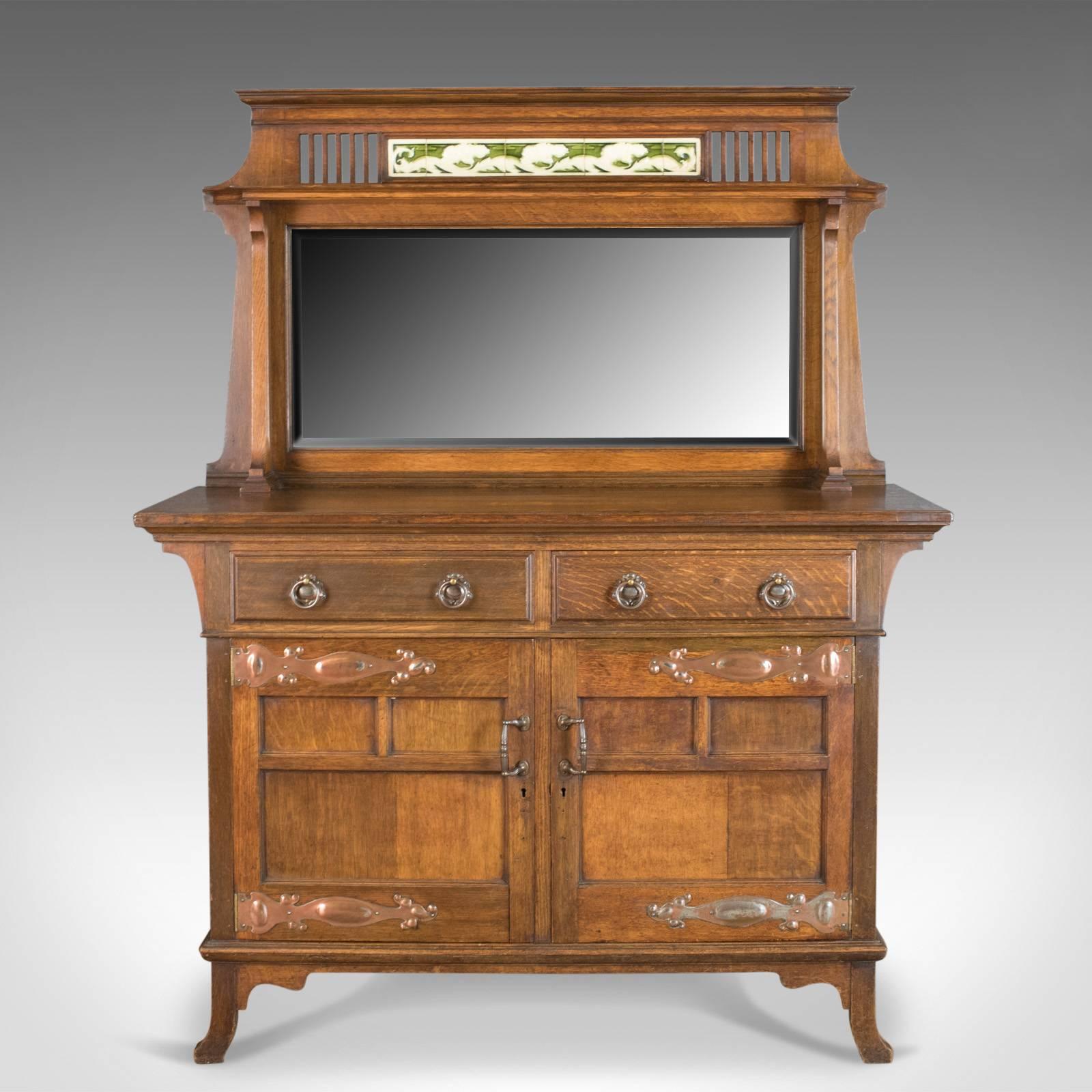 This is an antique sideboard, English, oak, Arts & Crafts cabinet in the liberty taste dating to circa 1900.

Of quality craftsmanship in well figured English oak
Displaying wisps of medullary rays in the wax polished finish
In the taste of
