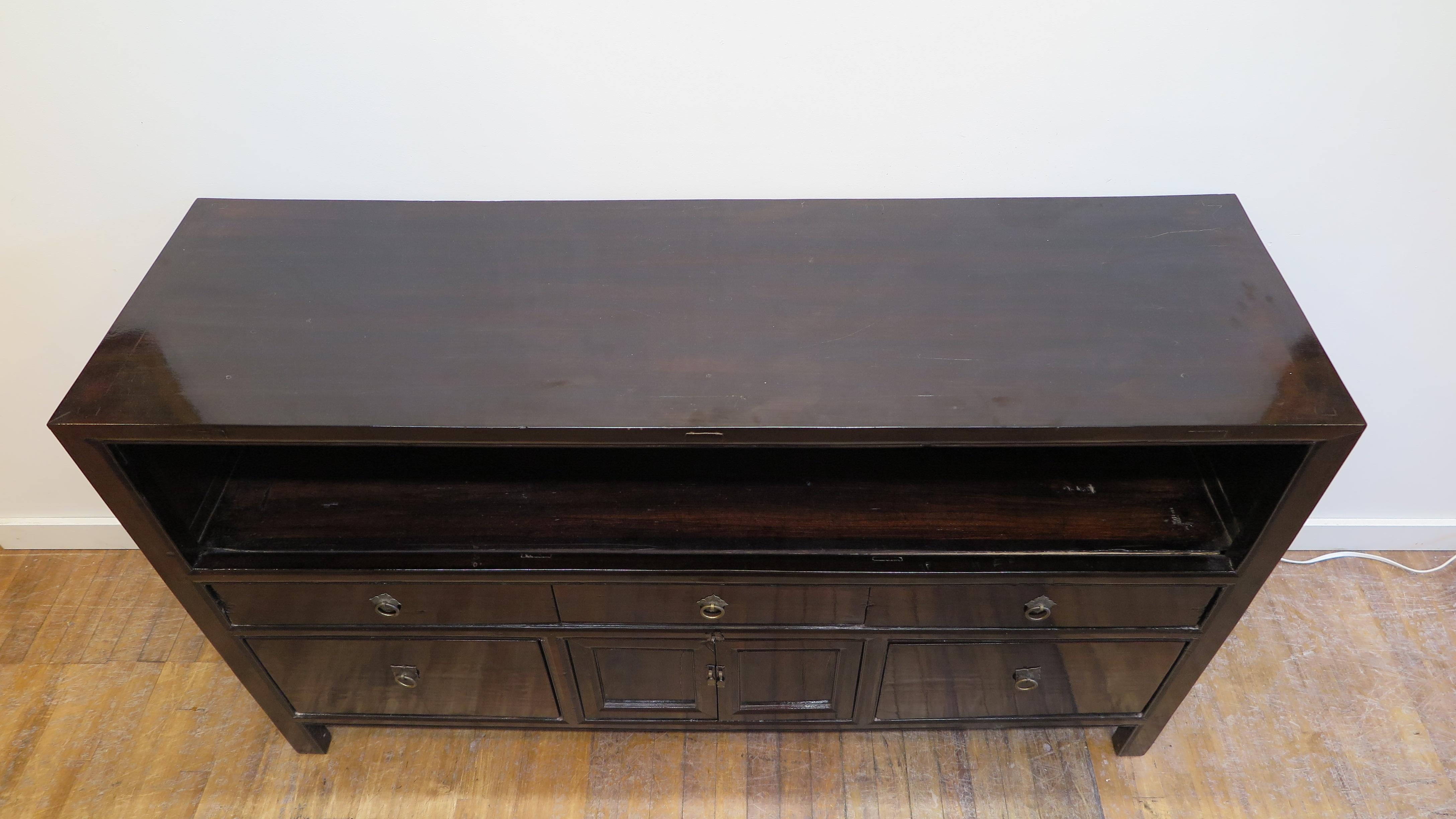 A Chinese antique sideboard end of the Qing Dynasty early 20th century, 1900 -1910. Elmwood sideboard with open upper case platform, having five drawers and a center small compartment cabinet for storage. Color is a dark brown.  This piece works