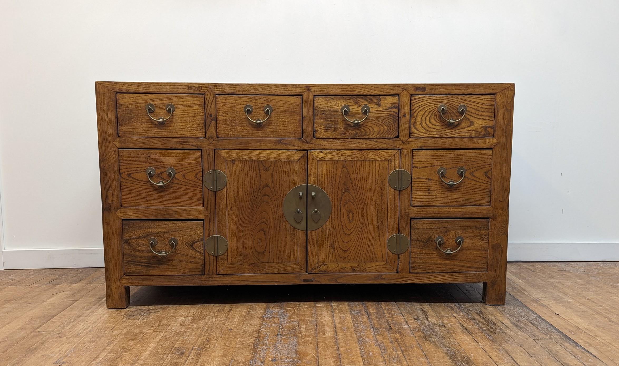 Antique Sideboard of Elm Wood.  Antique Chinese Sideboard.  Early 20th century eight drawer sideboard with cabinet storage in the middle.  Warm colored rich Elm wood has a very natural sensibility.  The drawers and cabinet shelves are as deep as the