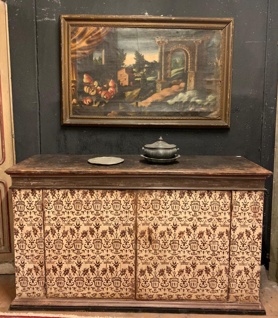 Antique sideboard in lacquered and painted wood with typical texture of the time, built in the 17th century for a palace in Florence (Italy), earth colors and warm tones make this type very elegant and suitable for any interior, it has only a shelf