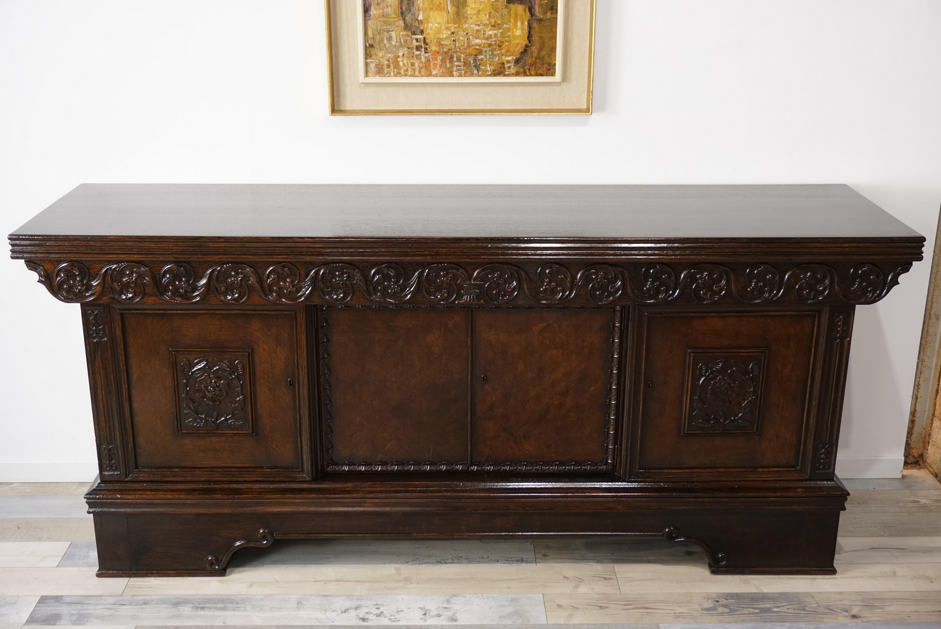 Old oak wooden sideboard or antique buffet, work late 19th-early 20th century, neo-Renaissance style and finely carved scrolls, roses and foliage, consists of four doors and three drawers belt. All in very good state of conservation given its age!