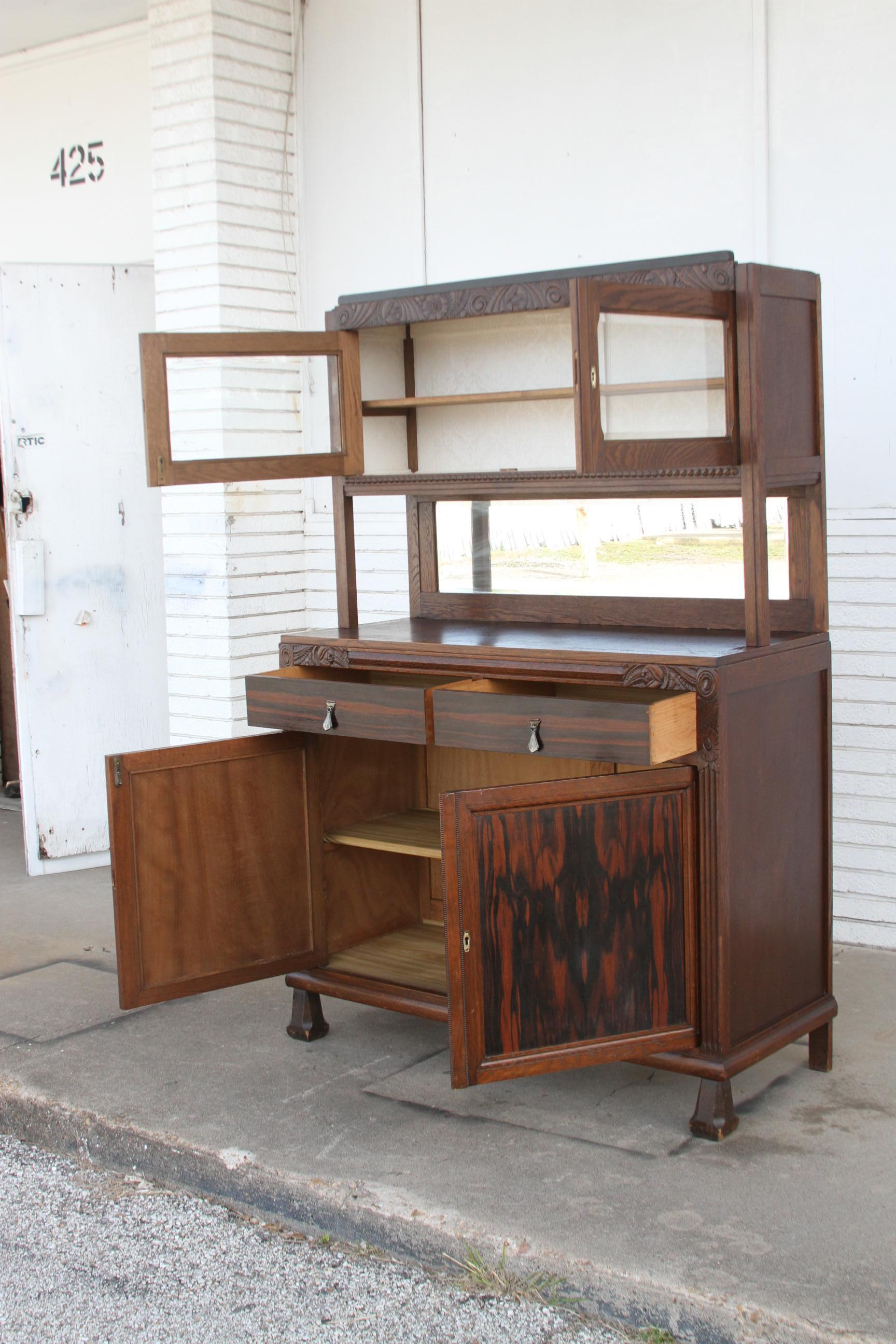 This is an antique Sideboard. It's made of walnut and rosewood. It's has nice carving along its edges. The top has 2 doors that reveal pie storage. The center is the cooling place for hot pies. There are 2 drawers and 2 lower doors for lots of