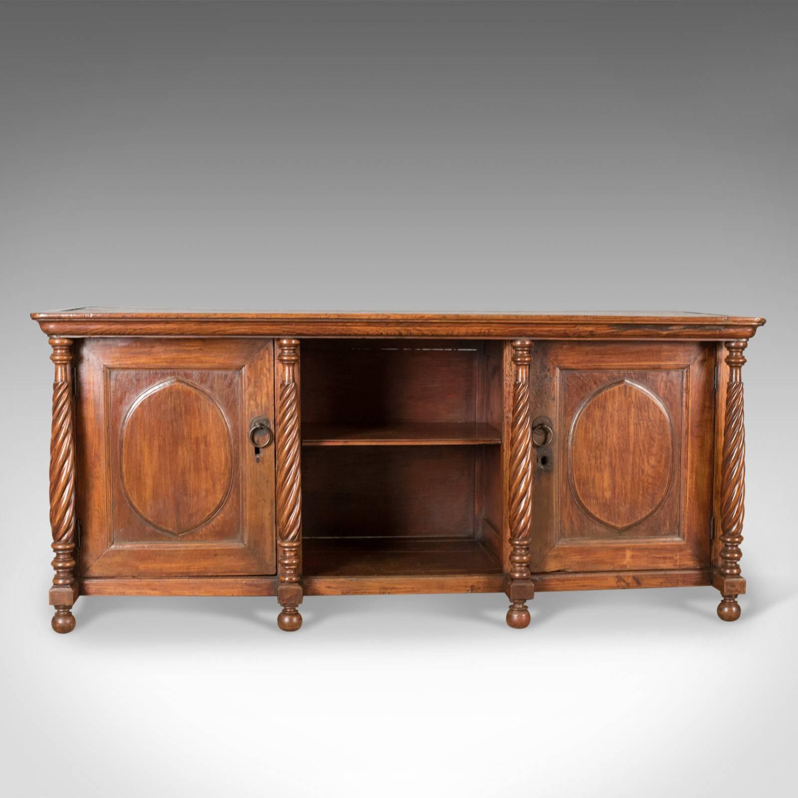 This is an antique sideboard, a colonial cabinet in fruitwood, a cupboard dating to the early 20th century.

Attractive russet tones to the fruitwood with a desirable aged patina
Raised on bun feet and featuring four, tapering barley twist