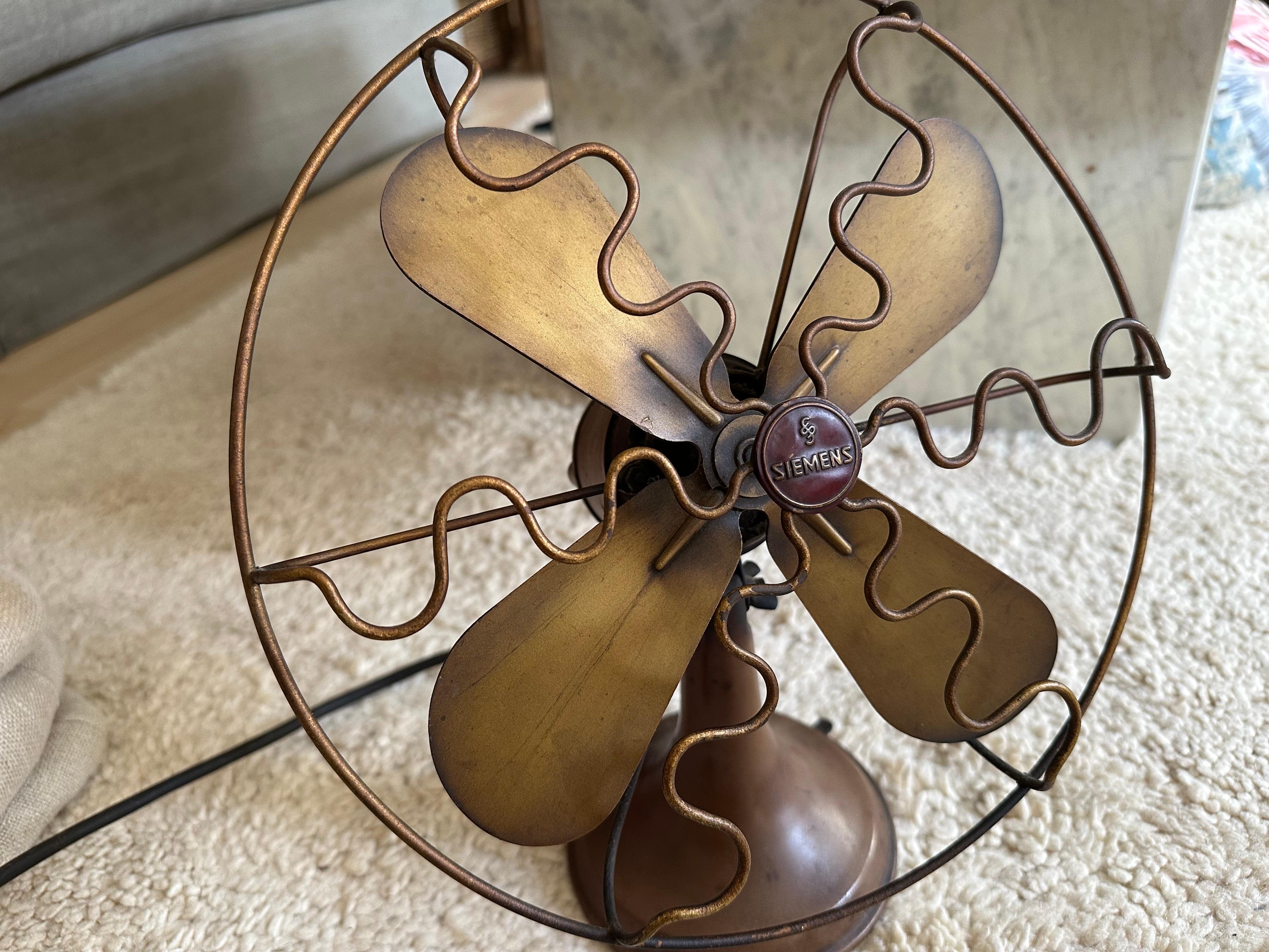 This striking antique Siemens fan from the 1920s is a fine example of early industrial design and the elegance of the Art Deco era. The beautifully curved frame is made from rich, dark Bakelite, a highly desirable early plastic known for its