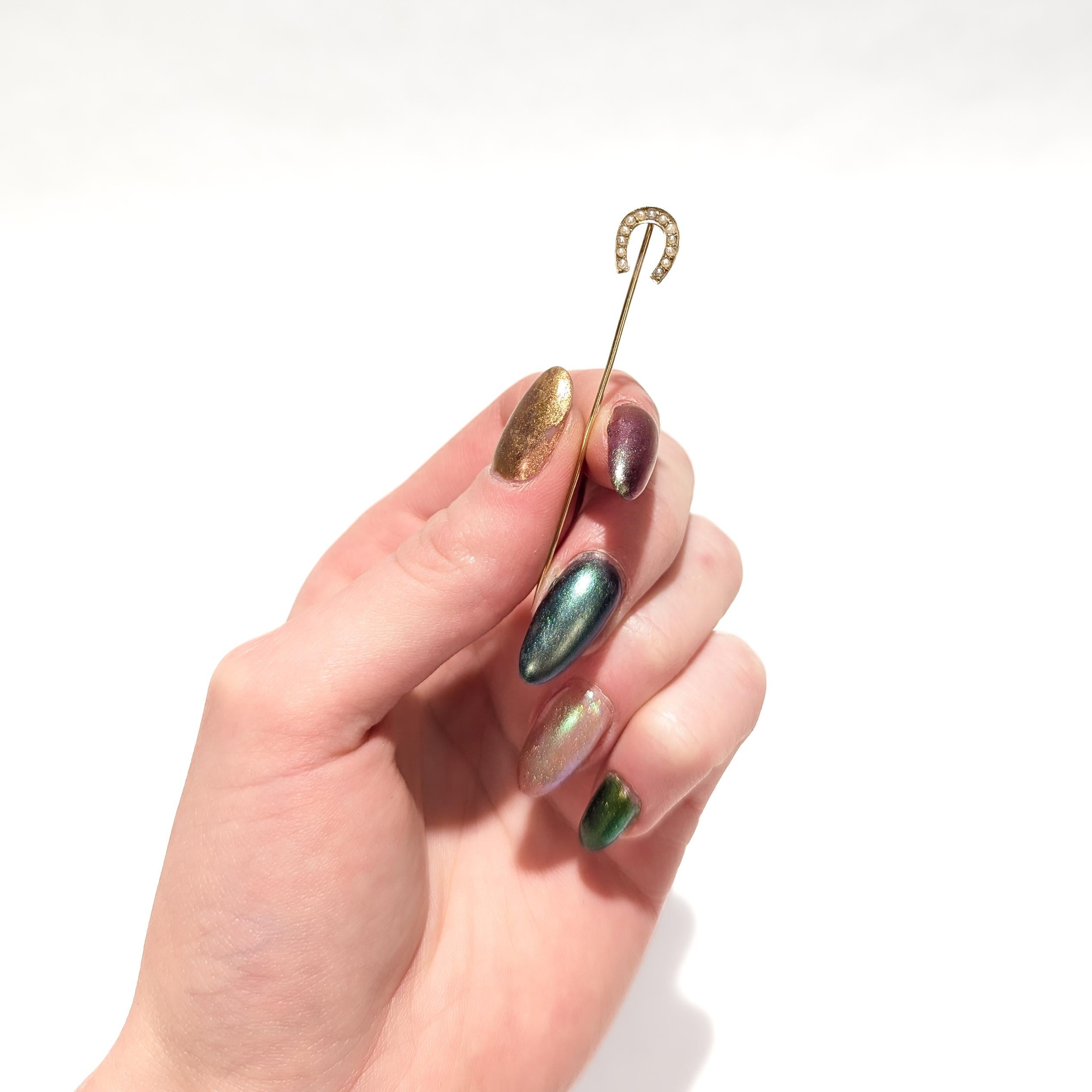A fine, signed antique gold & pearl stickpin.

In 14 karat yellow gold.

In the form of an horseshoe with prong-set pearls throughout. 

Marked to the reverse 14k and with an 'arrow' maker's mark.

Simply a wonderful stickpin!

Date:
20th