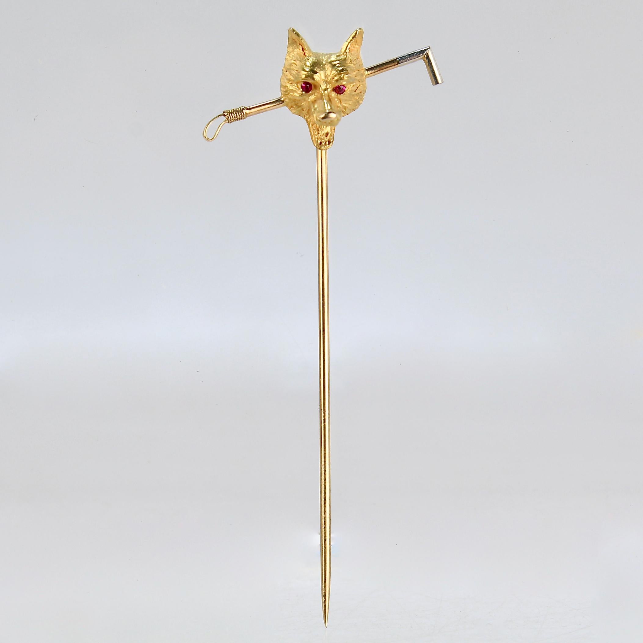 A very fine antique equestrian stickpin.

In the form of fox head and riding crop. 

Flush set with two small rubies as eyes and platinum-topped to the tips of the crop.

Signed with a partial maker's mark. Likely for Bippart & Co. 

Simply a great