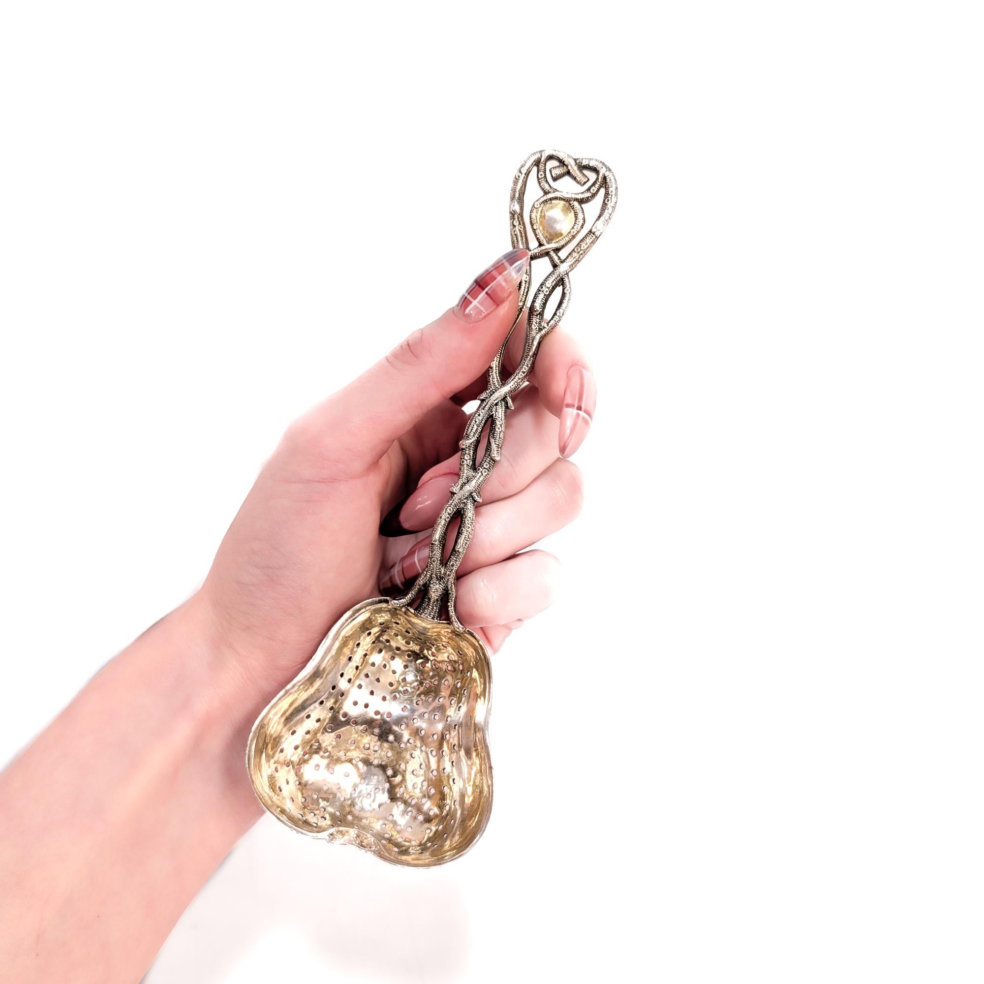 Ein schönes russisches Teesieb aus der Mitte des 19.

In 84 Zolotnik Silber.

Von Carl Gustav Ekqvist aus St. Petersburg.

Die figurale Schale in Form einer Birne wird von einem verschlungenen 