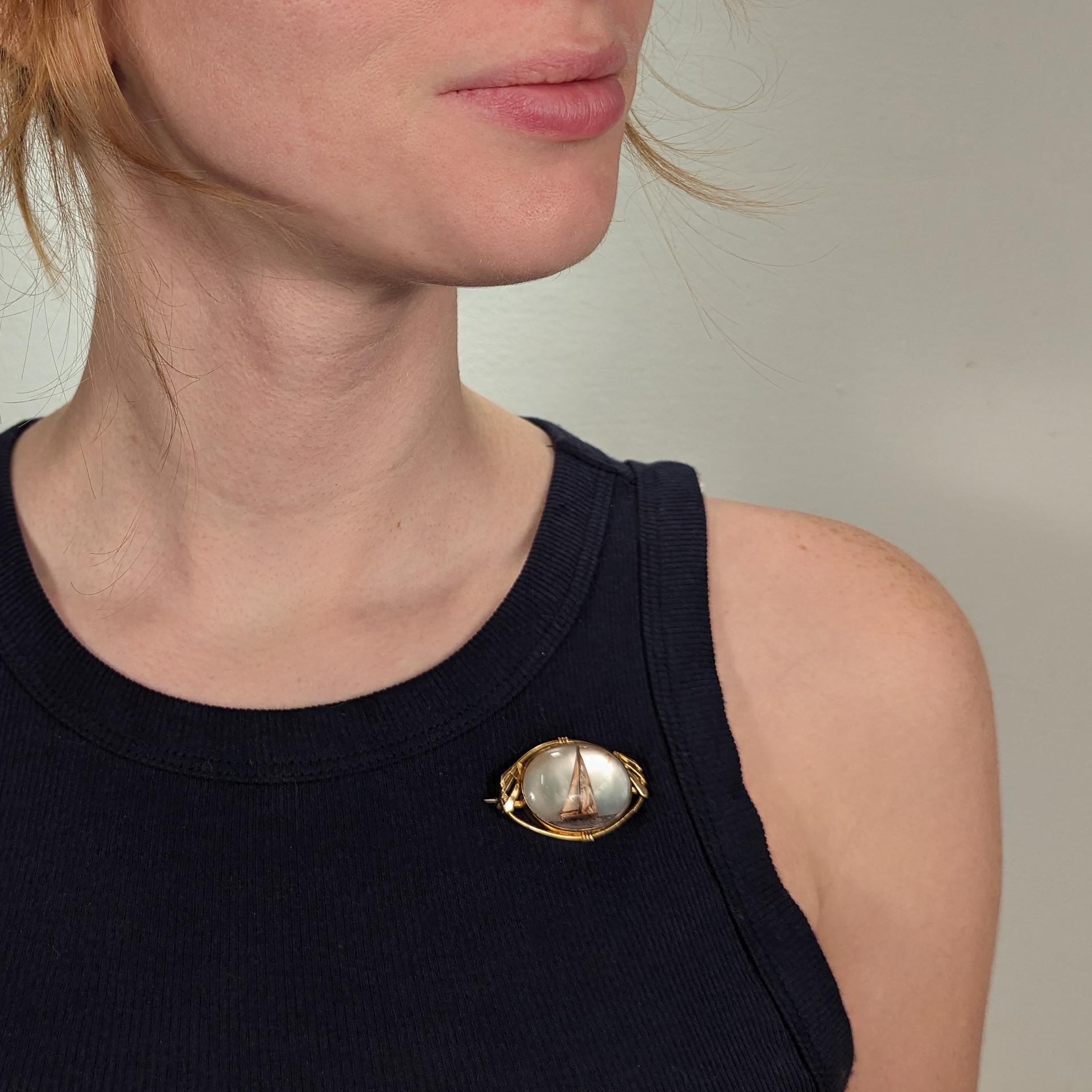 Eine schöne signierte Art Deco amerikanische nautische Modeschmuck Brosche.

Von AMCO Jewelry aus Providence, RI.

Mit einer vergoldeten Art-Déco-Fassung und einem Medaillon aus Perlmutt mit einem Segelboot auf See unter der Lünette (in Anlehnung an