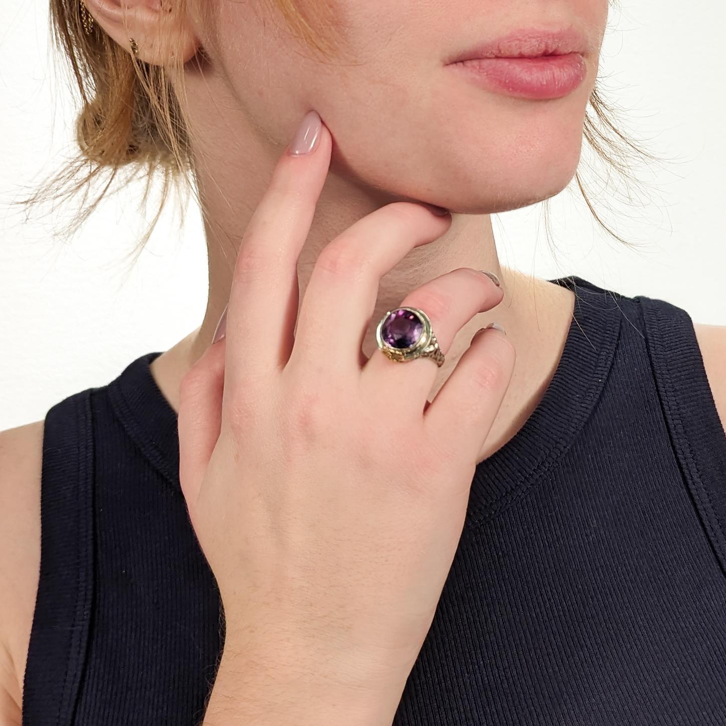A fine antique Art Deco ring.

In 18k white and yellow gold.

By the Art Deco period jewelers Baskin Bros. of New York, New York.

Bezel set with a large round-cut amethyst to its center.

The ornate white gold filigree setting has flower and leaf