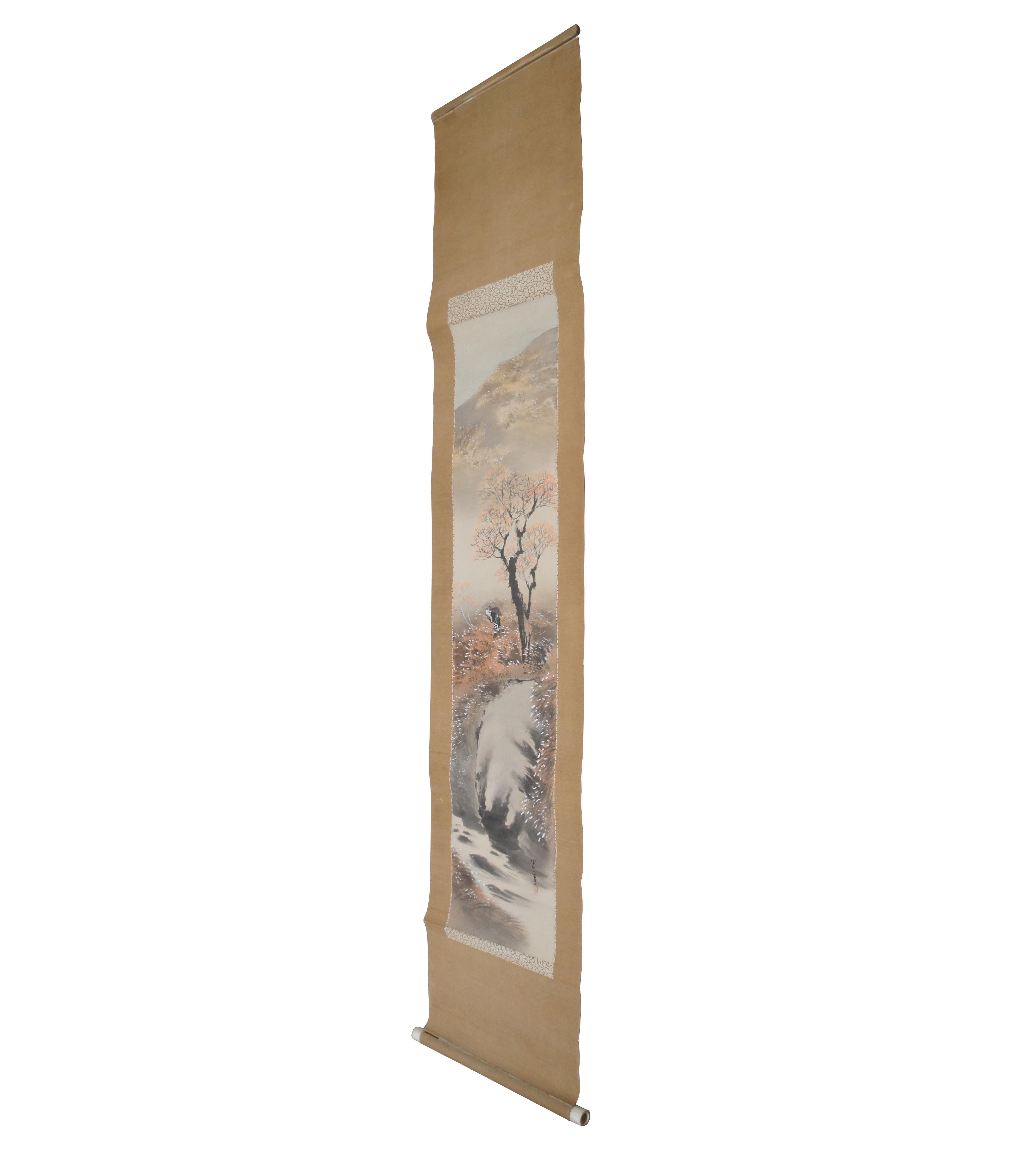 Signed antique Asian watercolor on silk landscape painting showing a small waterfall over a creek, topped with a tree and a woman carrying a bundle of wood with a mountain in the background. Mounted on a beige wall hanging scroll.

??/shou xue/: