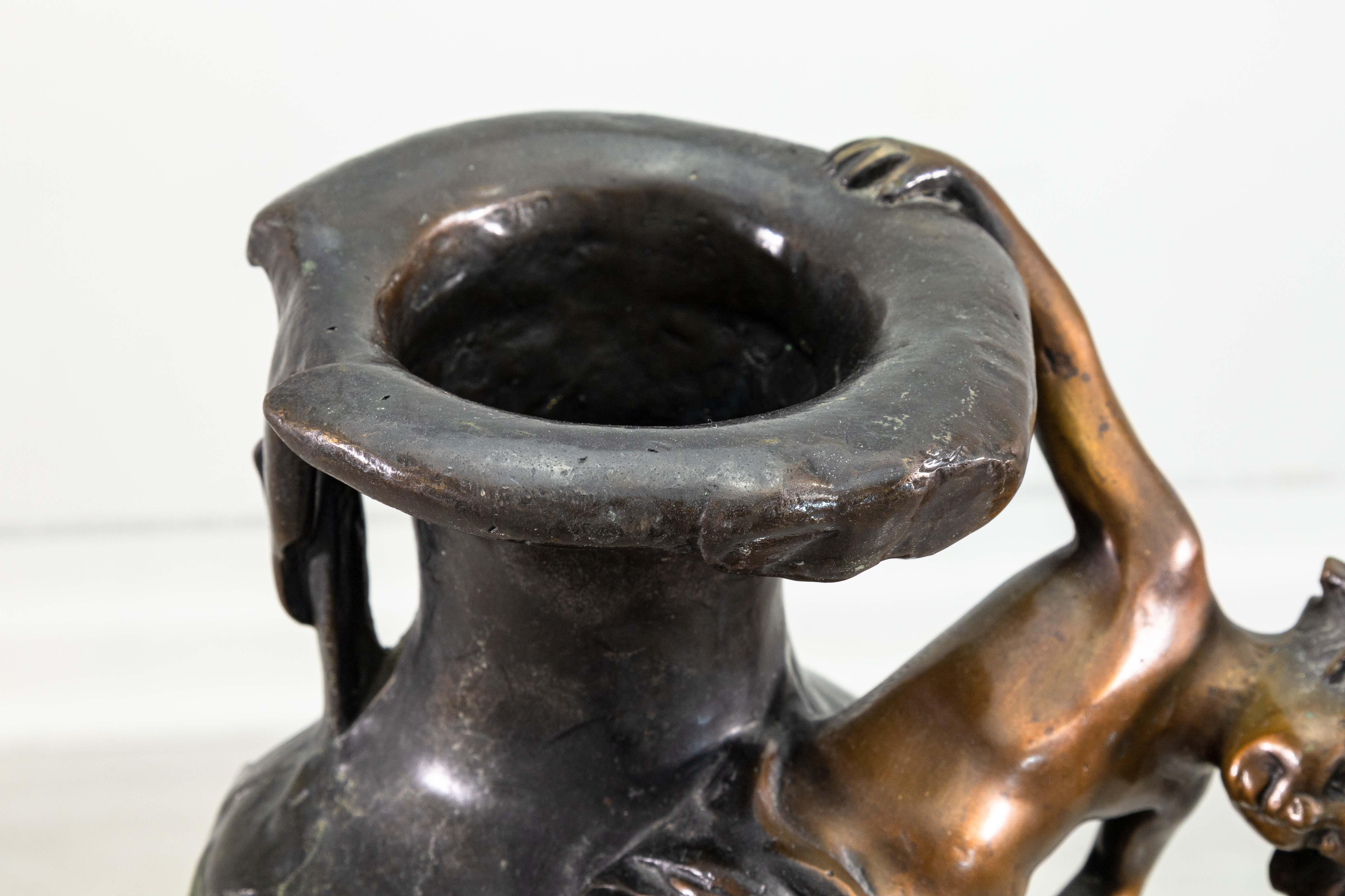 Una scultura da tavolo in bronzo di August Moreau. Questa graziosa scultura da tavolo in stile art nouveau è realizzata in bronzo fuso e poggia su una bella base di marmo affusolata. Questo vaso raffigura un cherubino che si arrampica sul lato del