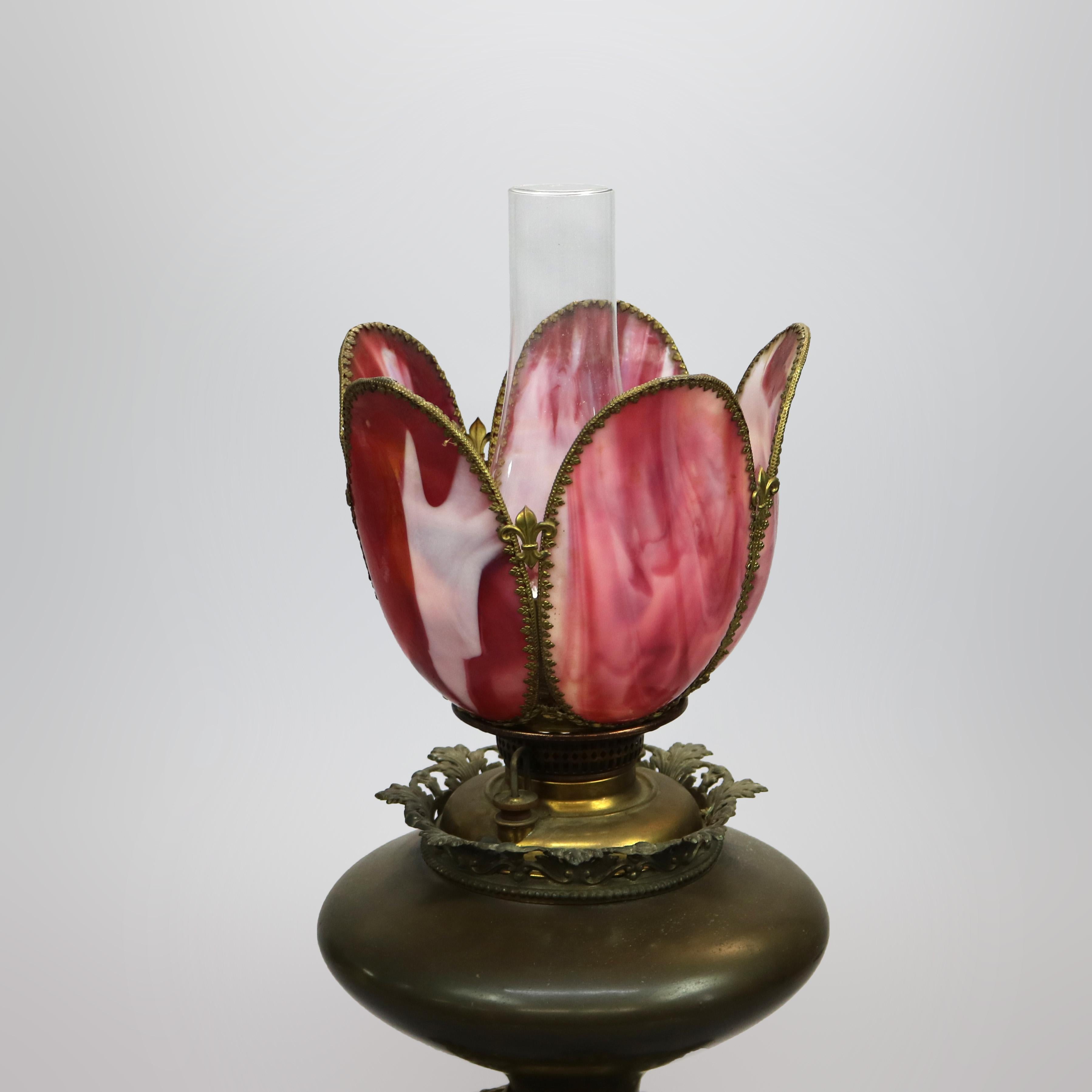 An antique and large Victorian oil lamp by Bradley and Hubbard offers cranberry slag glass tulip form shade over font with footed base, maker signed as photographed, c1890

Measures: 20.25