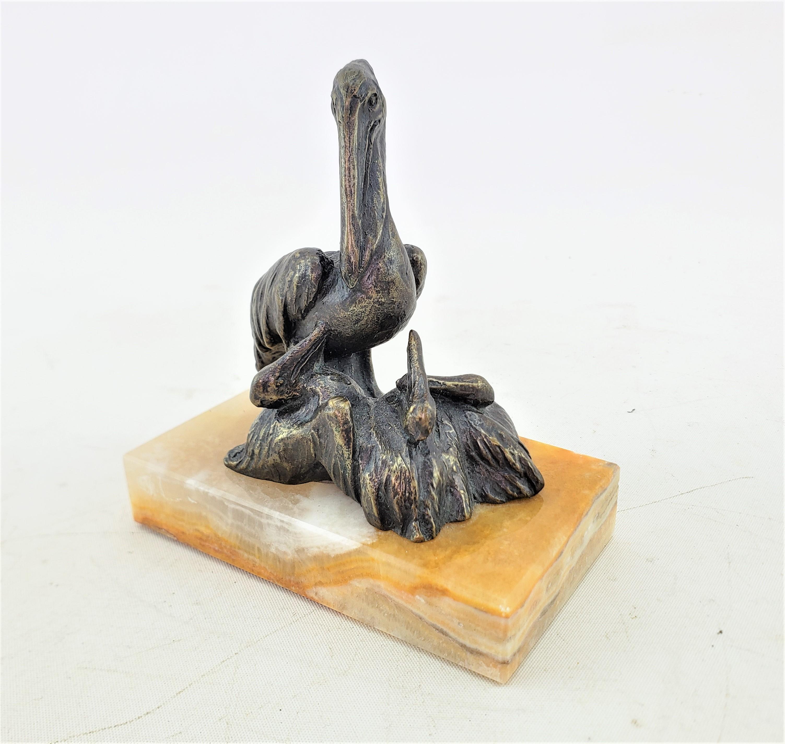 This small well executed sculpture is signed by an unknown artist and presumed to date to approximately 1920 and done in the period Art Deco style. The sculpture is composed of cast and patinated brass and depicts a pelican standing on a rocky
