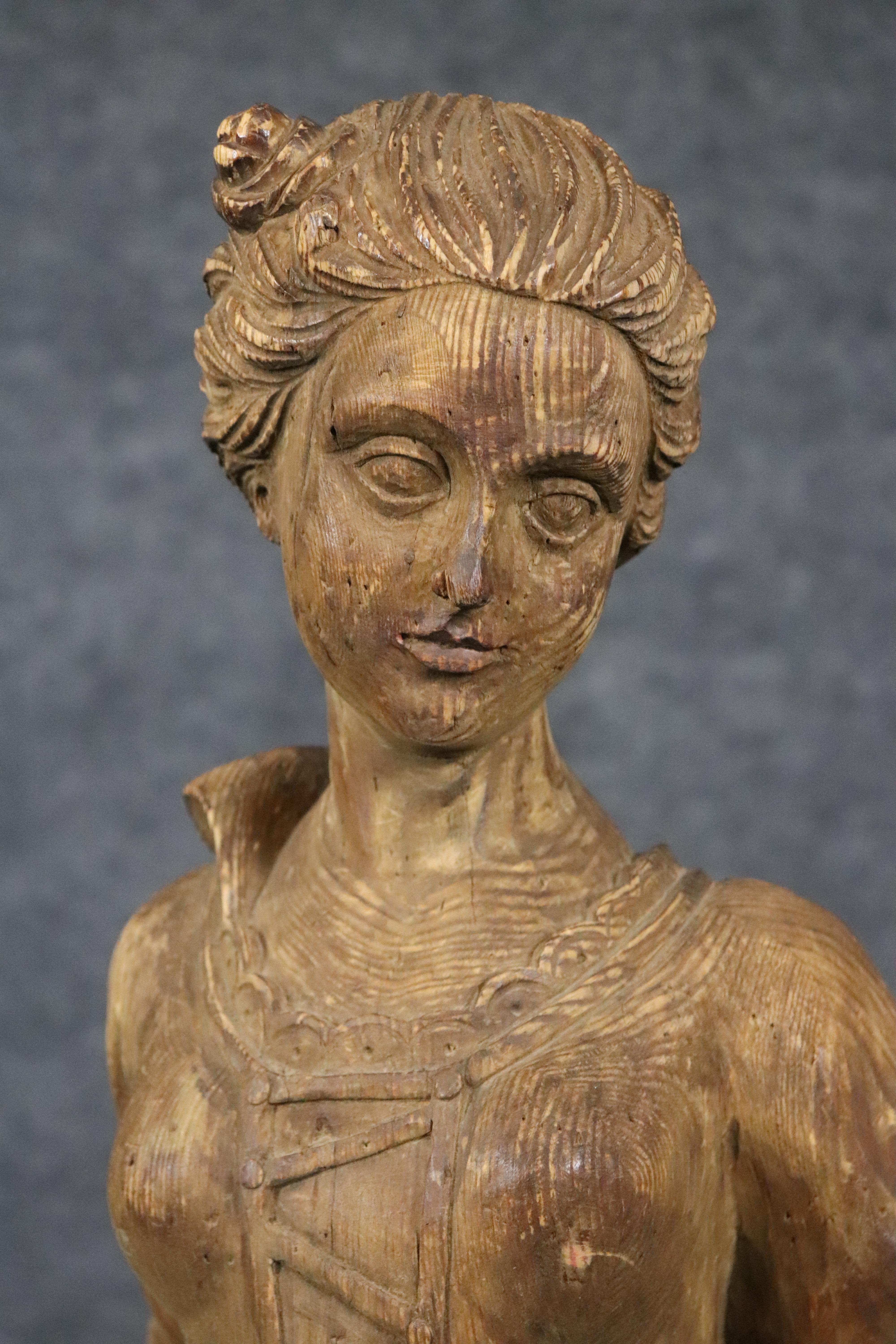 This is a gorgeous antique Chapman figural carved wood statue of a girl in European garb with her pet dog by her side. The statue is labeled Chapman and shows age splits and patina from age. The piece is in good condition and needs nothing to be