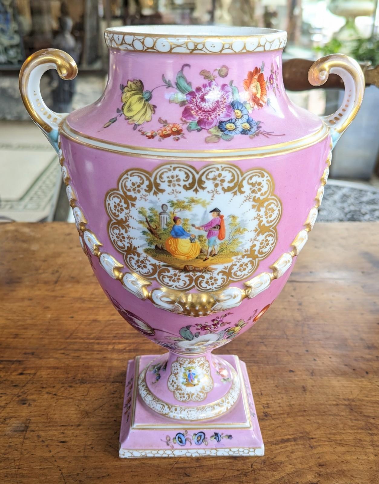 Stunning large antique Dresden porcelain vase in the shape of an urn, featuring a luscious pink color with gilded accents and a courting scene. Signed / hallmarked 
