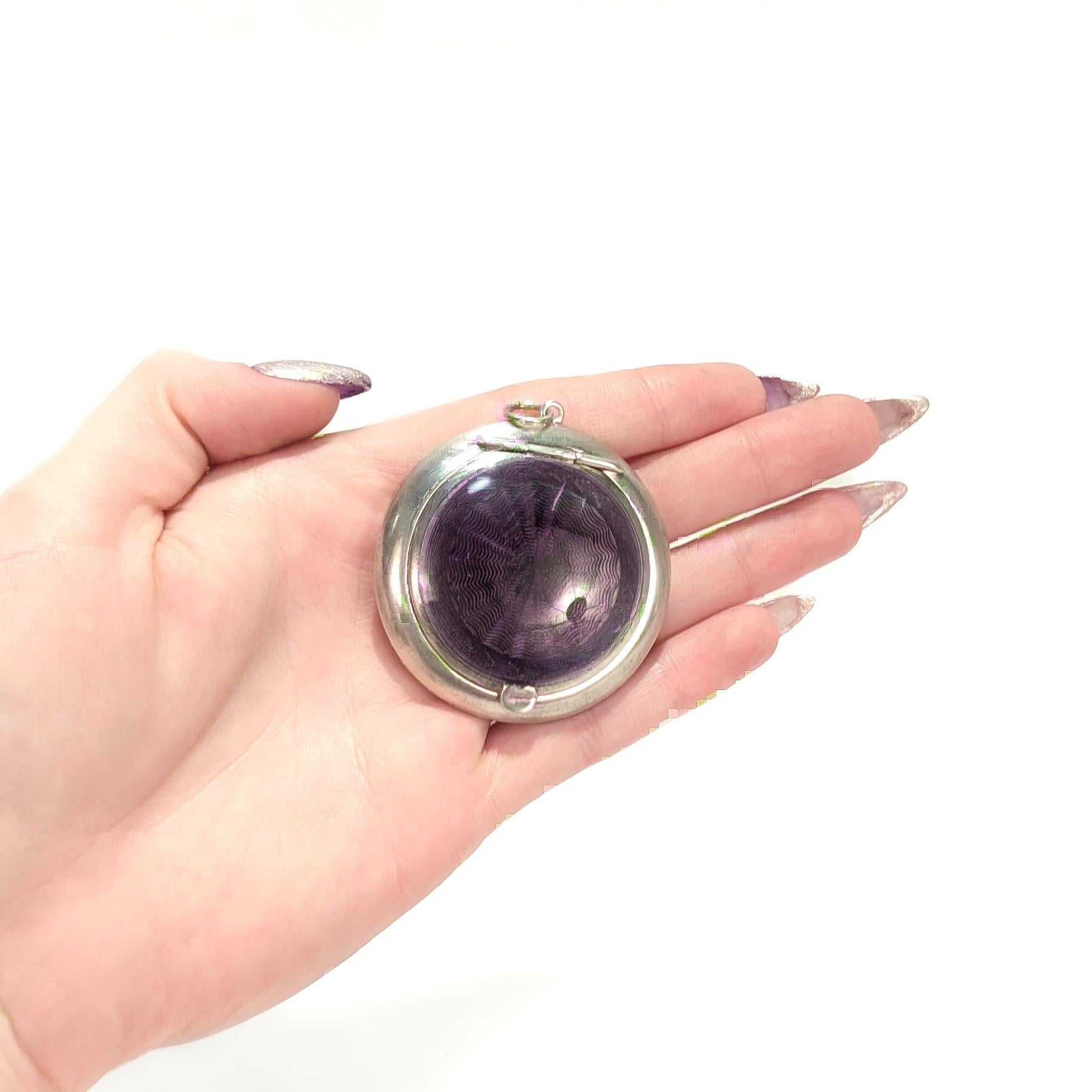 A fine English silver & enamel makeup compact.

By Crisford & Norris of Birmingham, England in 1919.

With geometrically patterned purple guilloche enamel to the lid. 

Fixed with an integral bail and jump ring.

Fully hallmarked to the