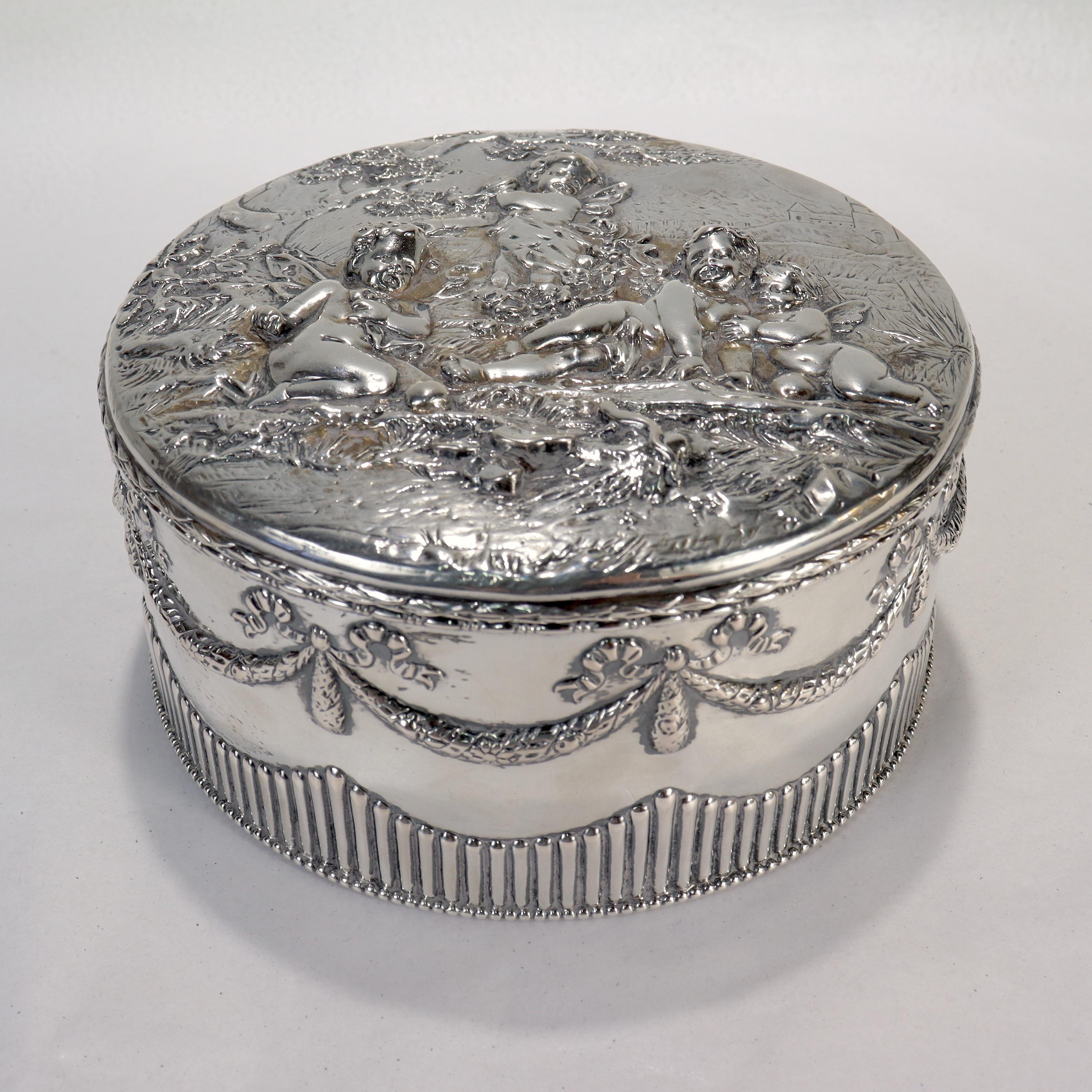 A fine antique German solid silver table box or casket.

By B. Nieresheimer & Söhne.

With Neoclassical swags & garlands to the sides, and a repousse Romantic style scene with cherubs (or angels) in a woodland setting by a stream to the top.

.800