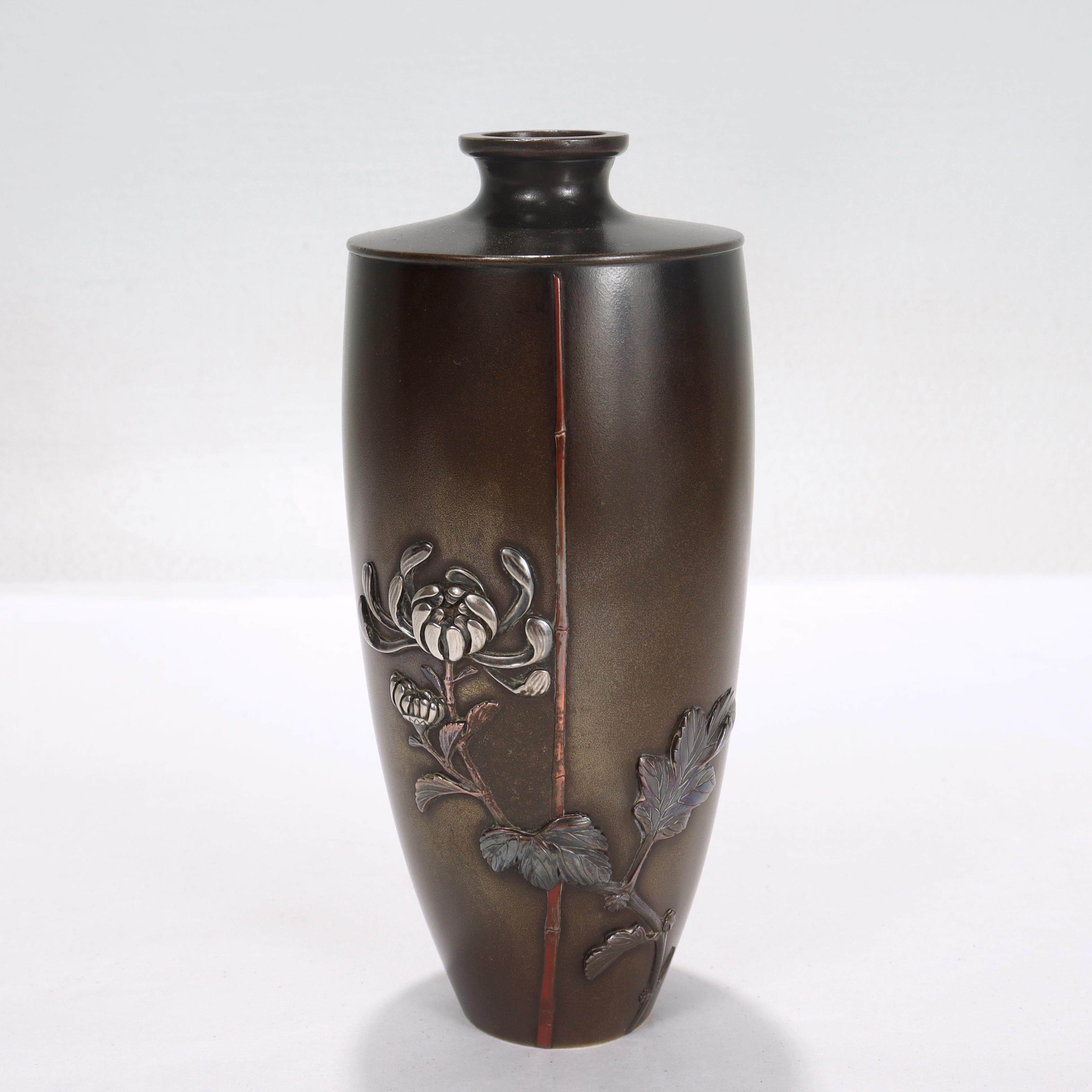 A fine signed antique Japanese Meiji period mixed metals vase.

By Miyabe Atsuyoshi for Inoue of Kyoto.

With a bronze body and decorated with inlaid gold, silver, and shibuichi in the form of a stylized chrysanthemum and bamboo.

Engraved
