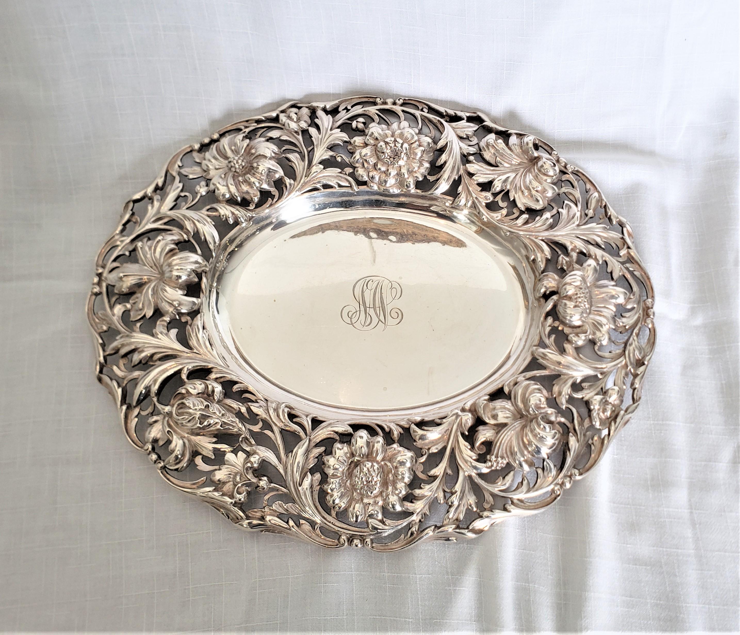 Esta antigua fuente o bandeja de plata de ley fue fabricada por la renombrada Tiffany and Co. de Estados Unidos aproximadamente en 1860 en el estilo victoriano de la época. Esta bandeja ovalada de plata de ley lleva un monograma y presenta un gran