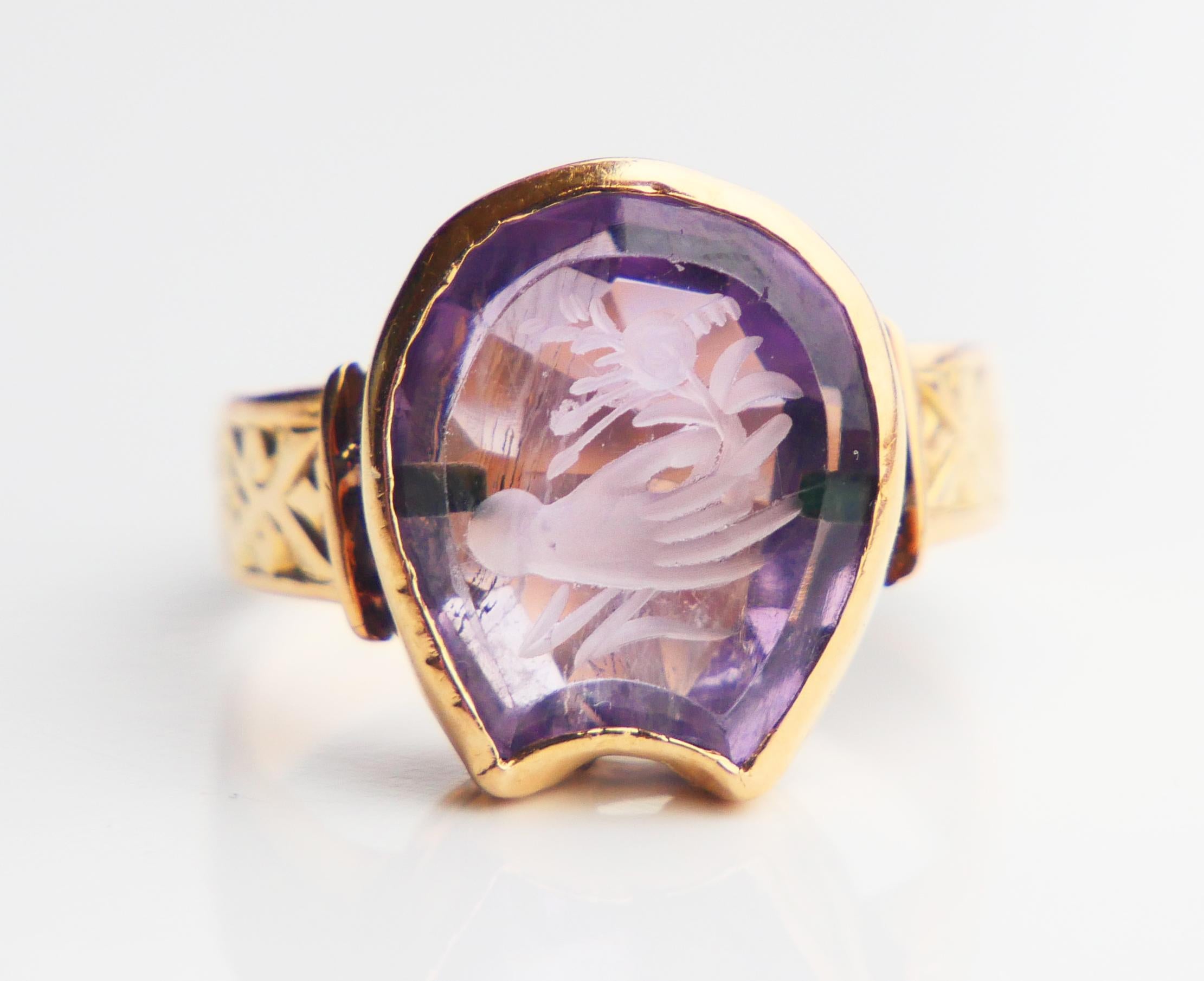 Nobility Intaglio Signet Ring for Men or Women. European , 19th - early 20th century. Swedish customs hallmarks 18K confirmation : 3 crowns. 
Intaglio of a Flower in a Hand, hand - engraved into the deep of  Horse - shoe or shield cut natural Purple