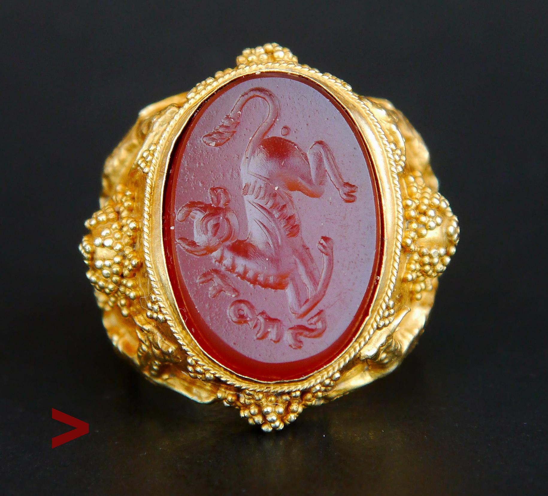 Unusual antique Gold and Carnelian Signet Ring with fine hand-carved intaglio of Taurus or Bull / Baal ? with short inscription in an unknown tongue.

Richly decorated surfaces of the shoulders and shank: relief stars and figures of running gazelles