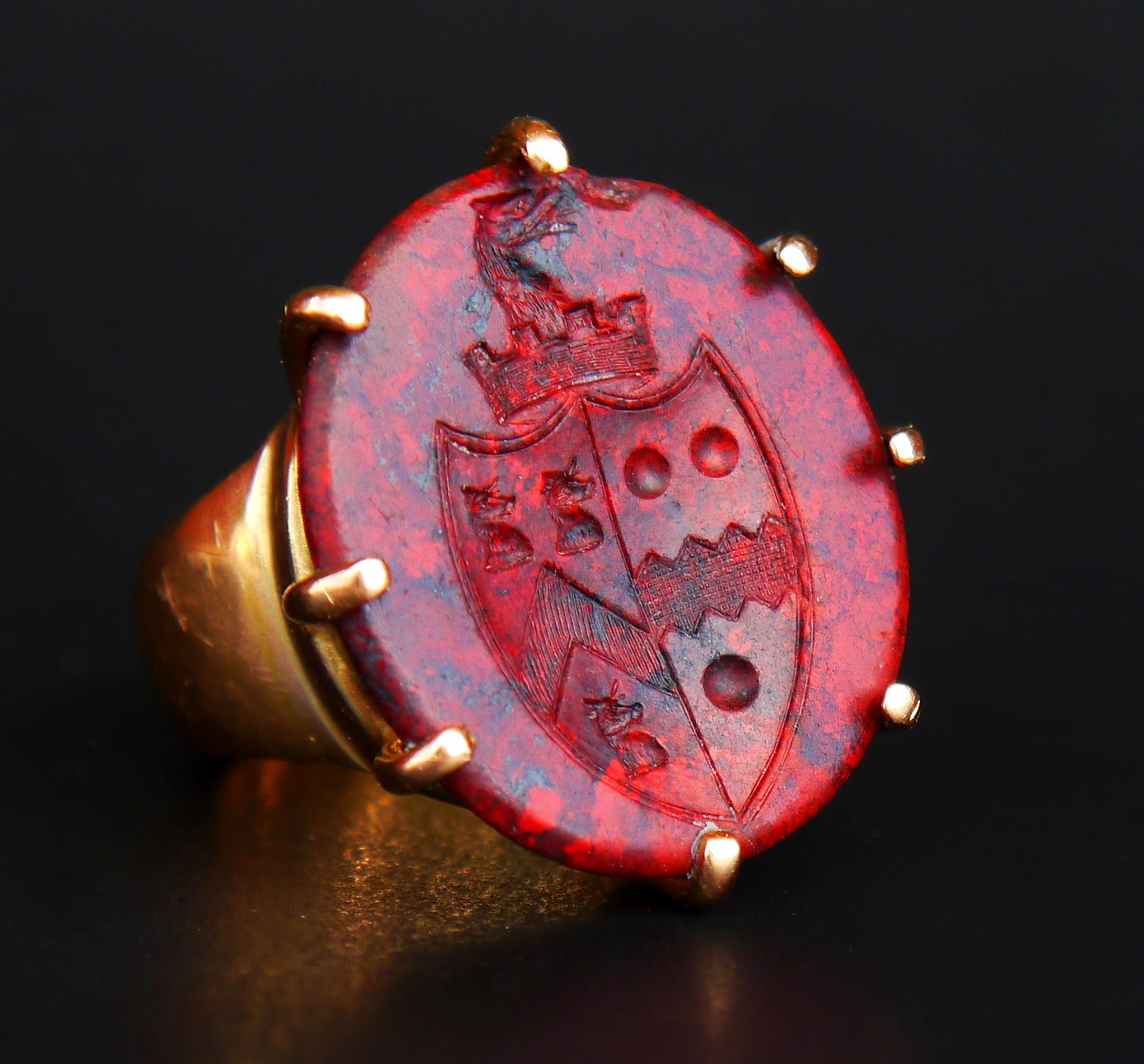 Bague chevalière en or et jaspe avec empalement héraldique de forme concave Intaglio de deux armoiries de familles nobles incrustées à jamais dans le rouge foncé de la pierre avec beaucoup d'habileté.

La texture de la pierre ressemble à celle du