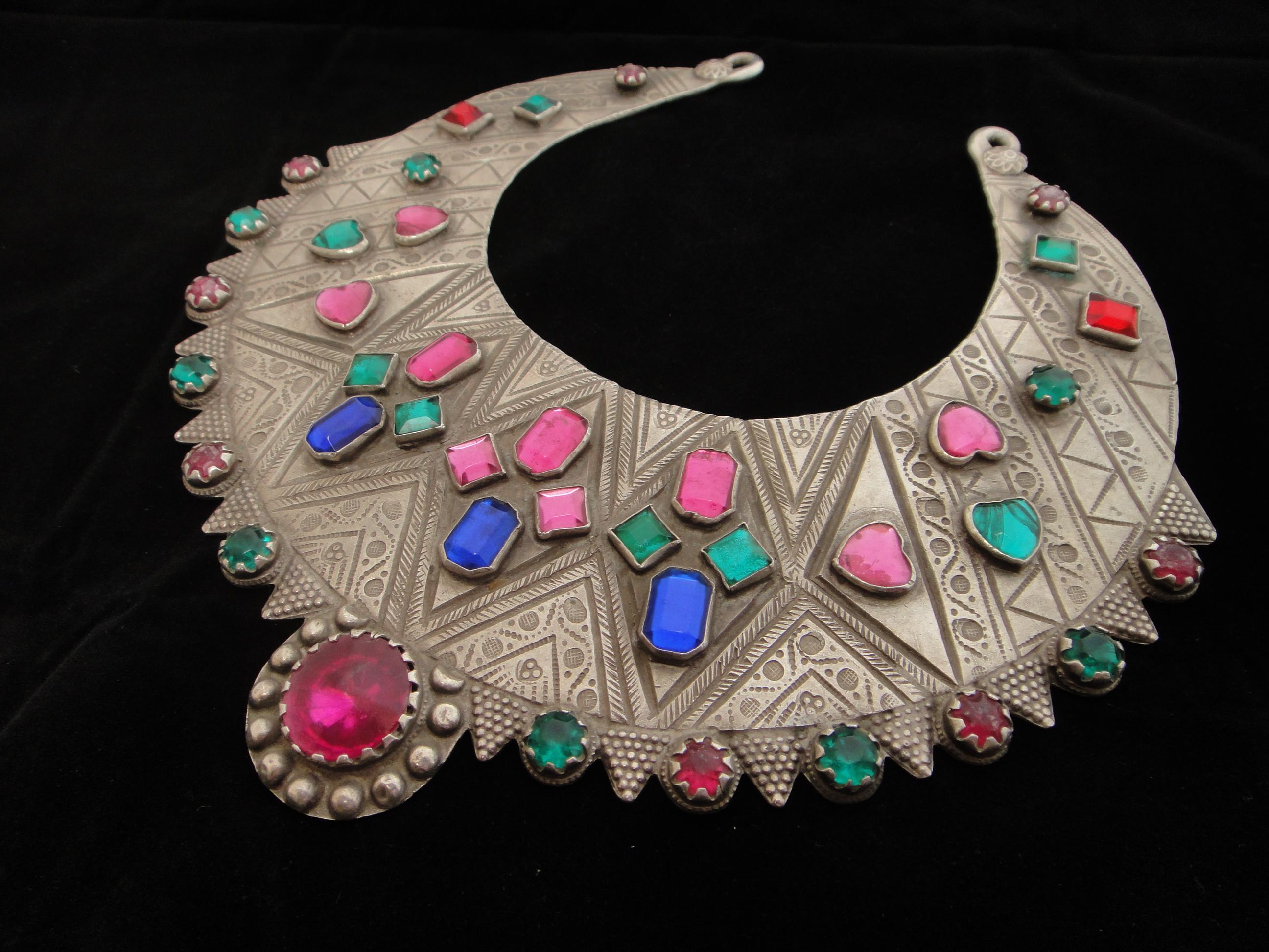 This unique silver chestplate is adorned with colorful glass cabochons and may have been made for a young bride. This antique peice is ideal for display, as dimensions are smaller than the average neck. 

