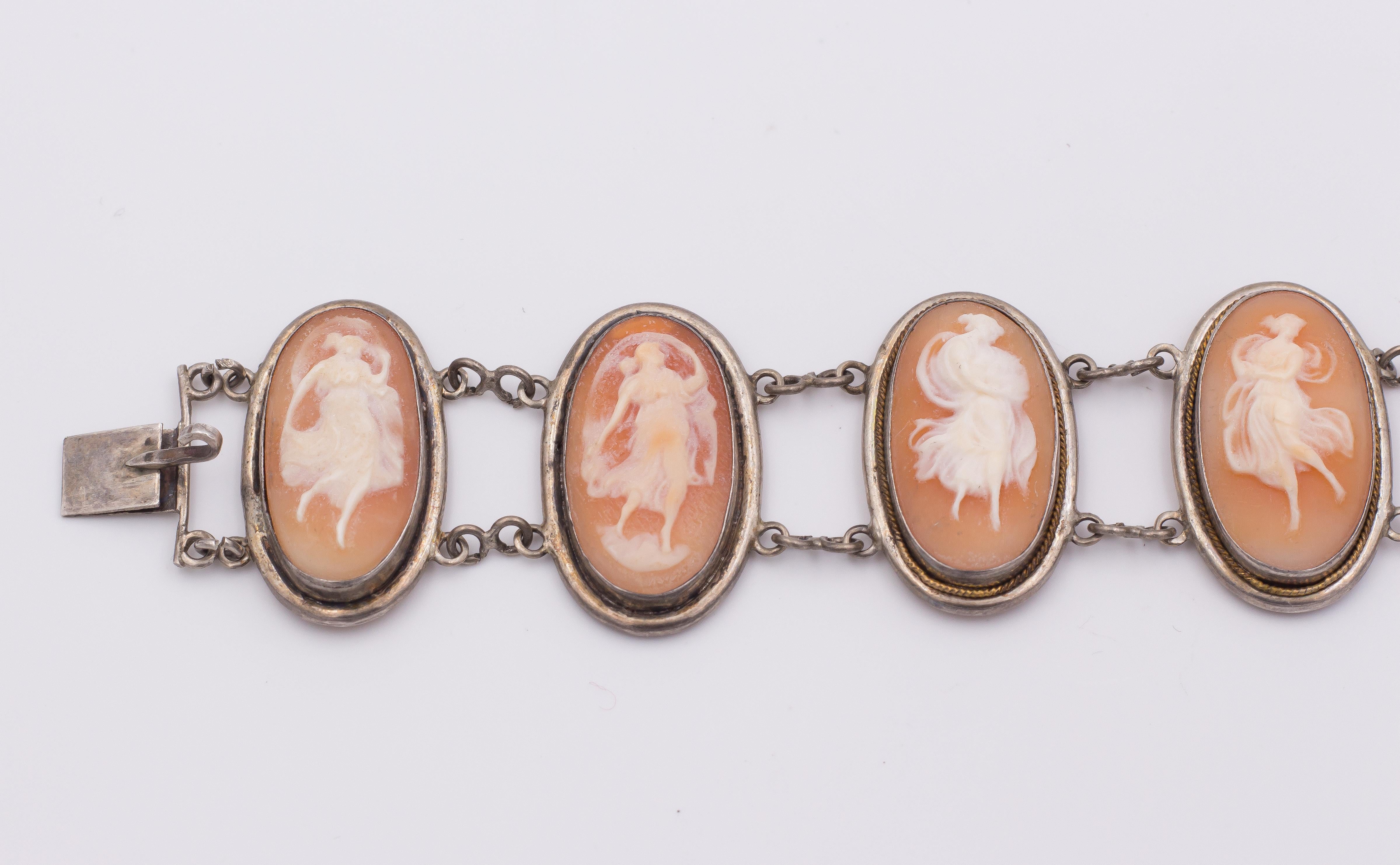 This antique bracelet, dating from the late 19th Century, is set with seven oval cameos: each one depicts a young woman dancing, with their clothes moving and dancing with them. 
Each cameo is connected to the other by two chains. 
The bracelet is