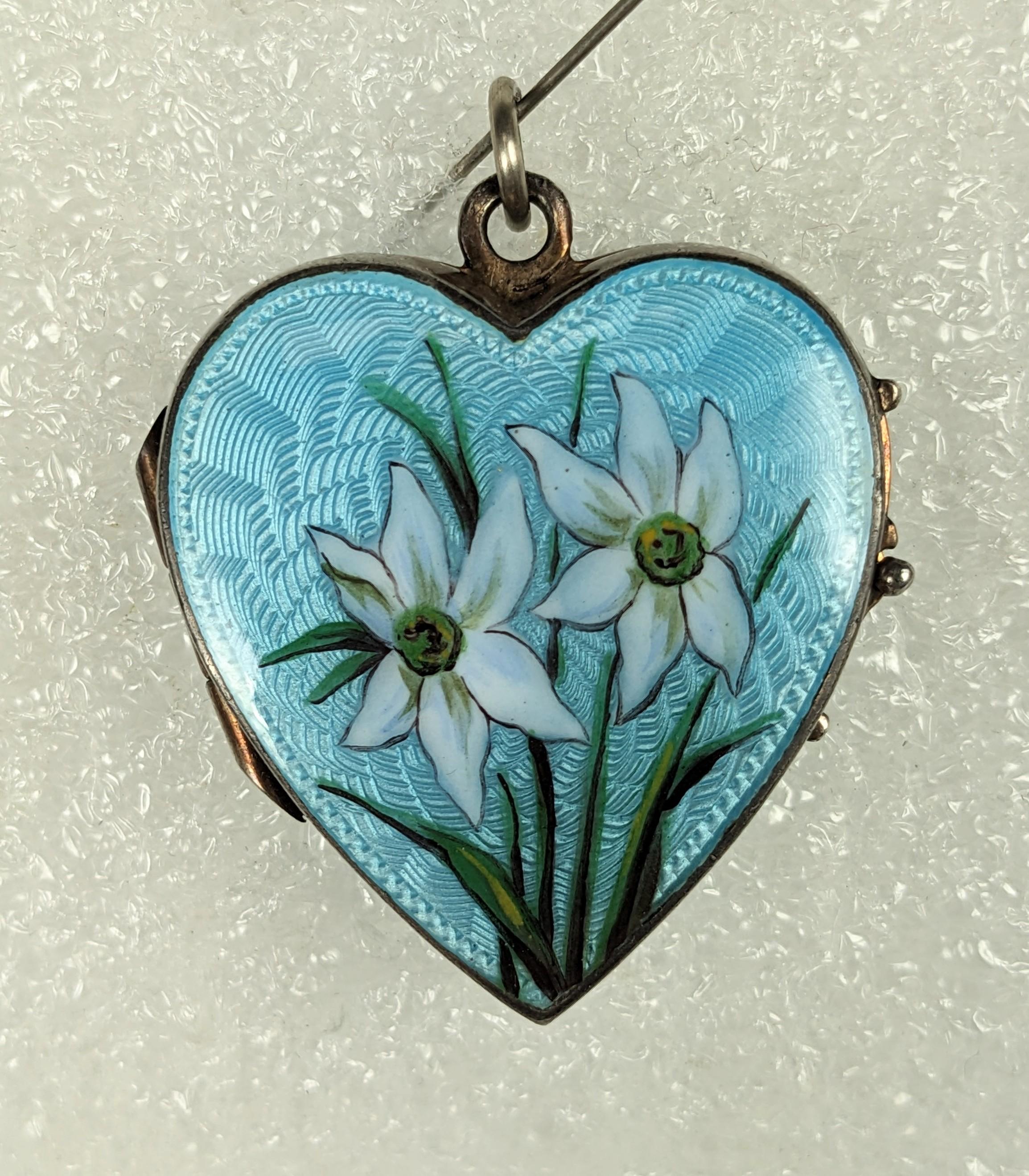 Lovely Antique Silver and Enamel Edelweiss Locket from the 1930's. Beautiful quality with aquamarine blue guilloche enamel on front and back. The face is decorated with hand painted edelweiss blooms. Double locket interior inserts are original. 1