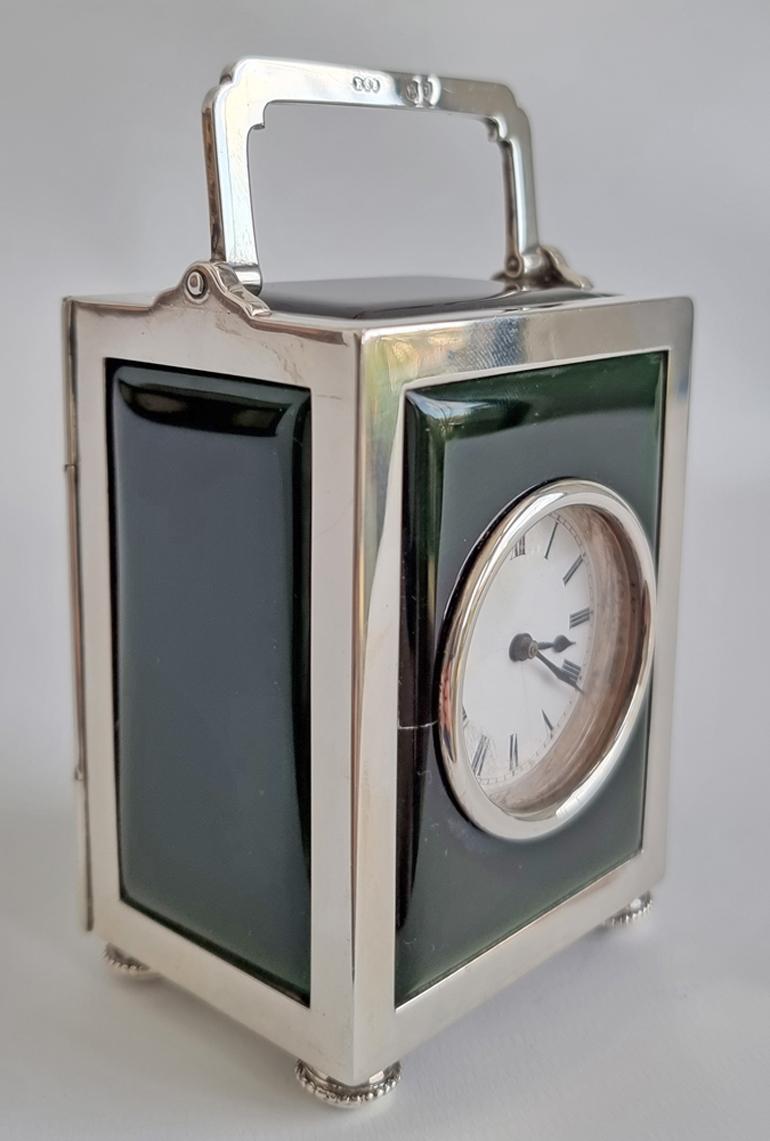 Very smart and chic silver carriage clock with panels of green foil backed glass. This gives a very fine effect as of guilloche enamel. White enamel dial with blued steel hands. The movement is a particular fine swiss made 8 day movement with