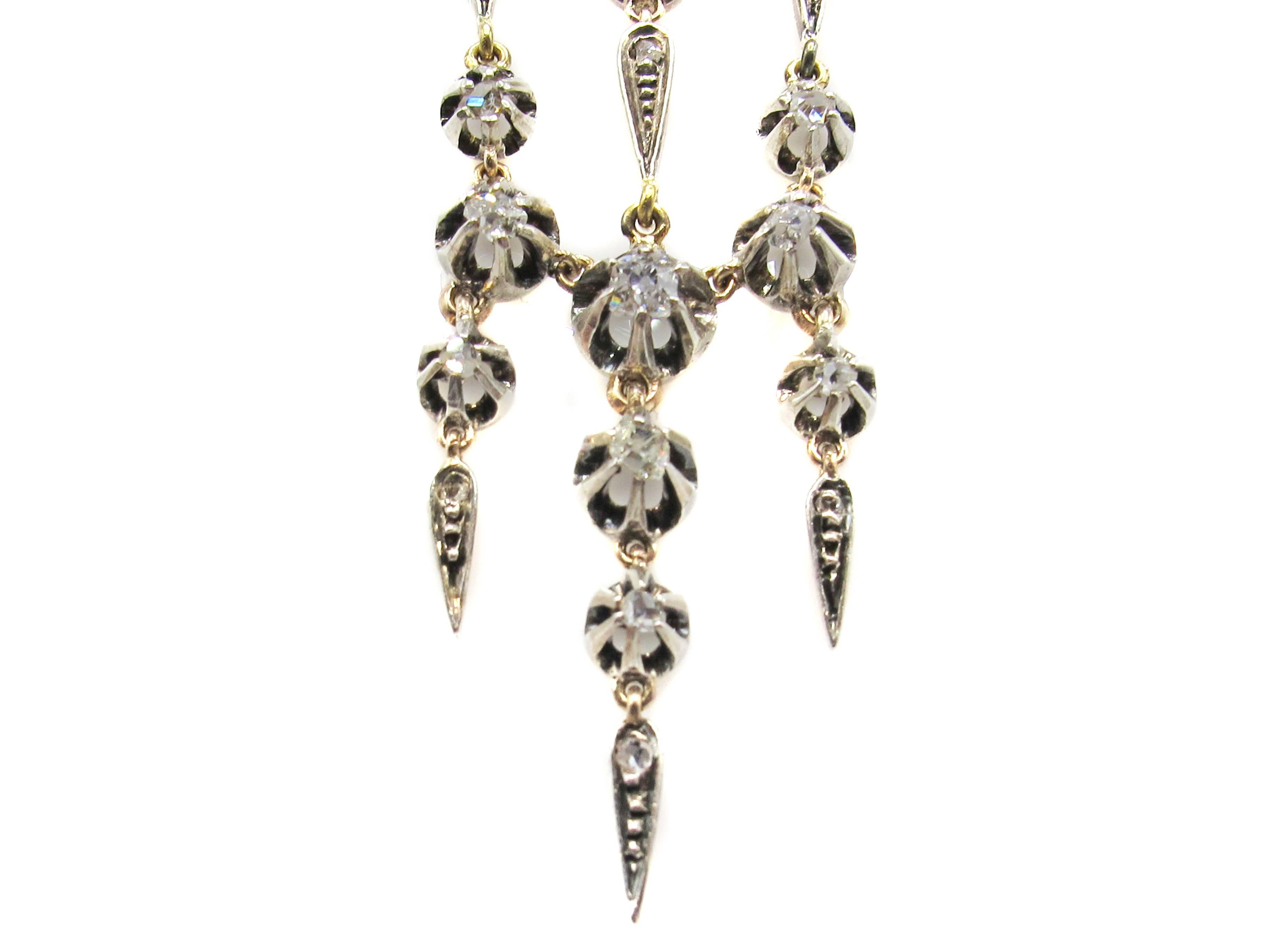 These unique early Victorian chandelier pendant earrings measure an impressive 3.75 inches in length from the middle of the hook to the bottom of the earring. Each old mine diamond is held by 5 extended silver prongs which rest on a base of rose