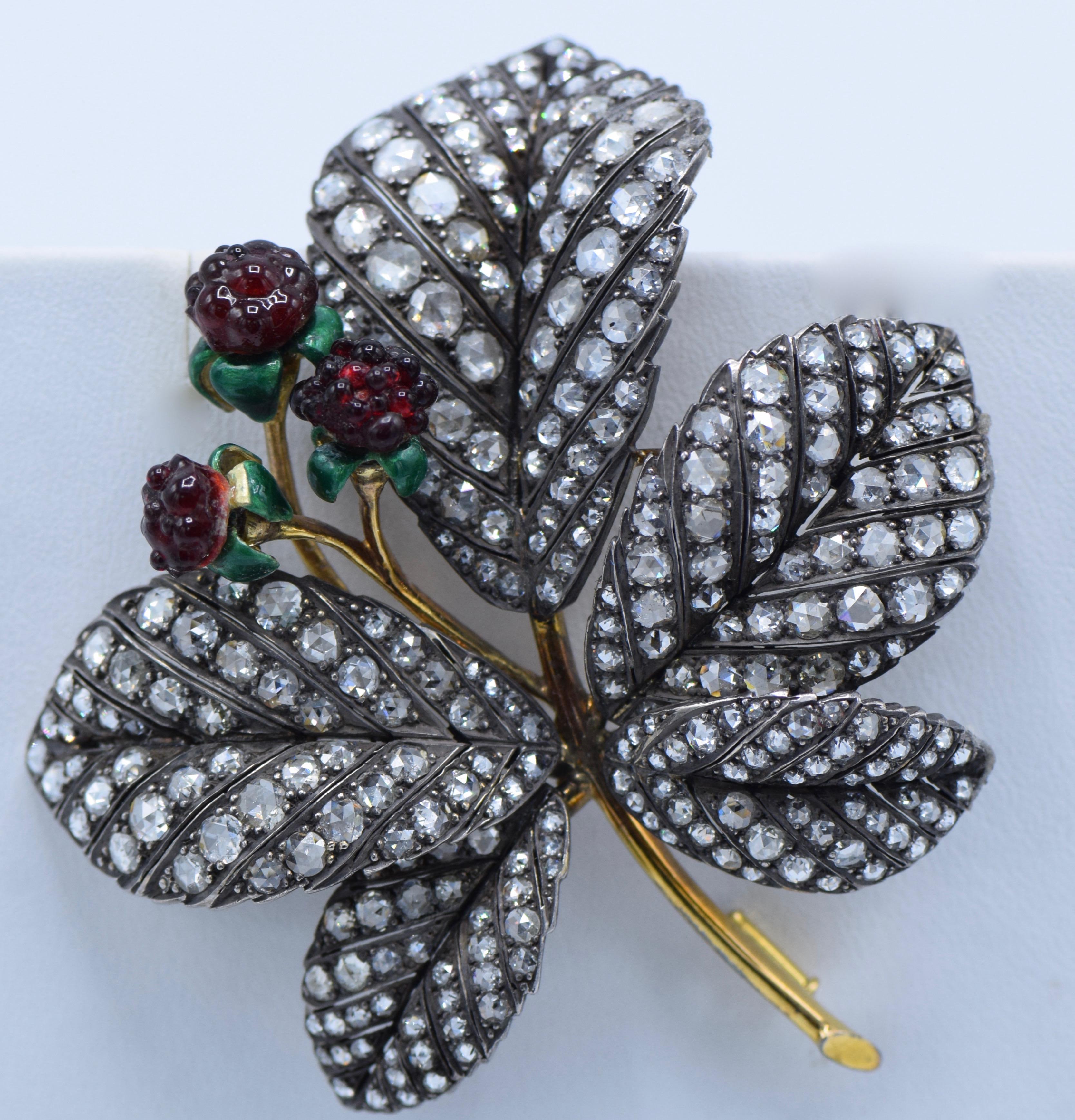 designed as leaf and enamel flower 

Late Victorian Diamond, Enameled and Gold Raspberry Brooch

Total Diamond weight: 10 carats

A cluster of three molded red glass berries with curling green enameled calyx,  TW., silver-topped yellow gold leaves.