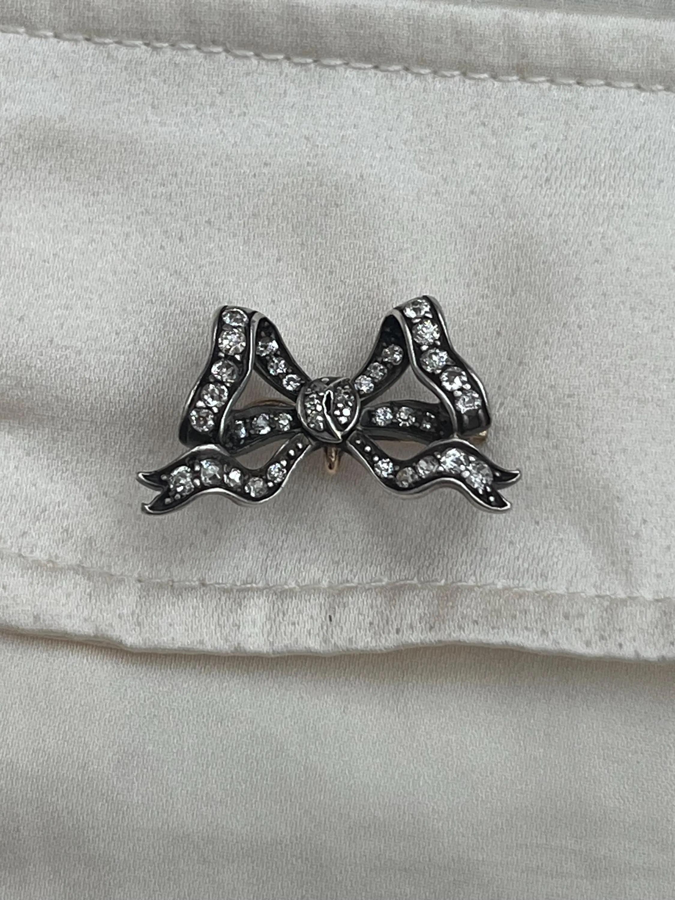 Broche ancienne en forme de noeud avec diamants

Or et argent 18ct 

L'artisanat victorien dans toute sa splendeur.

Cette broche à nœud en argent et en or met en valeur des diamants de taille ancienne dans un design classique du XIXe siècle,