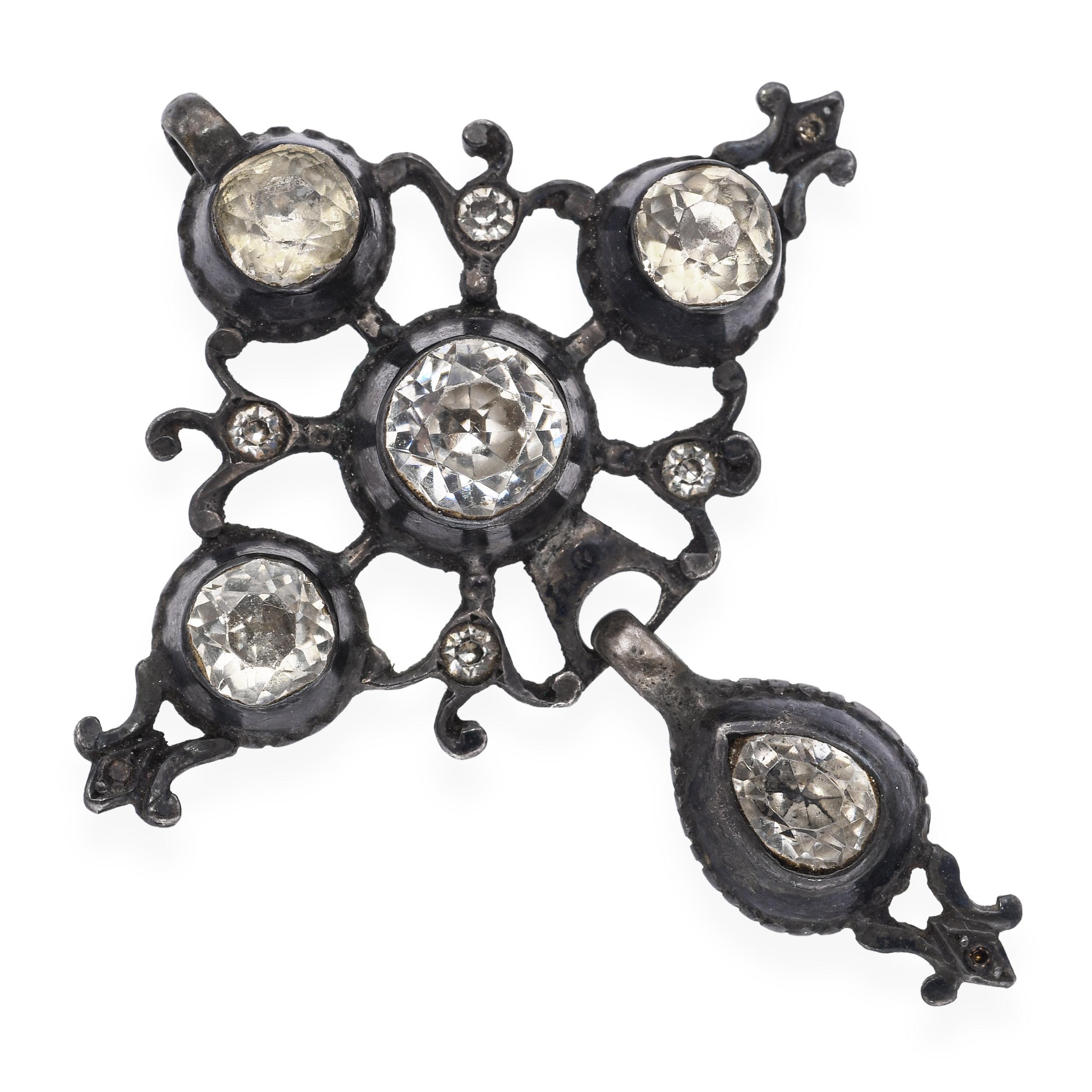 Ce pendentif en forme de croix en argent antique, serti de pierres en pâte taillées à l'ancienne, dégage un charme vintage et une élégance toute dévotionnelle. Les pierres sont individuellement serties à la main dans des montures ouvertes, ce qui