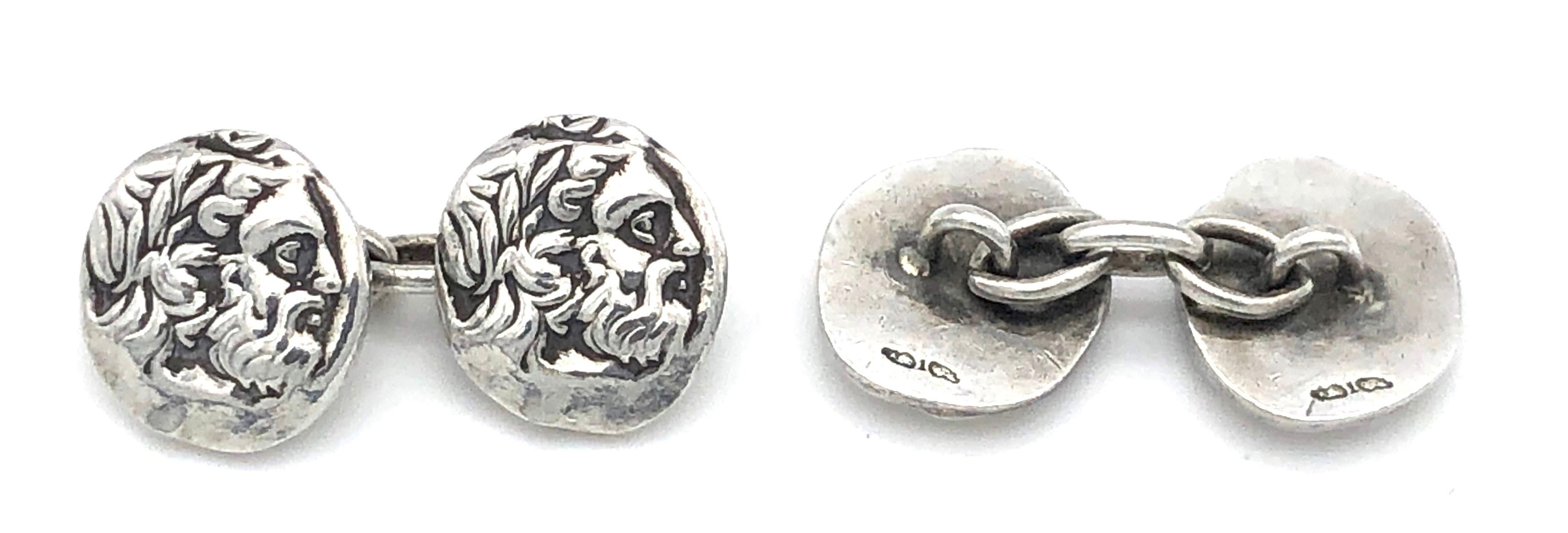 Los moldes de monedas de plata de la Antigüedad que representan el perfil de un dignatario barbudo con una corona de laurel se han convertido en un par de gemelos inusuales.
