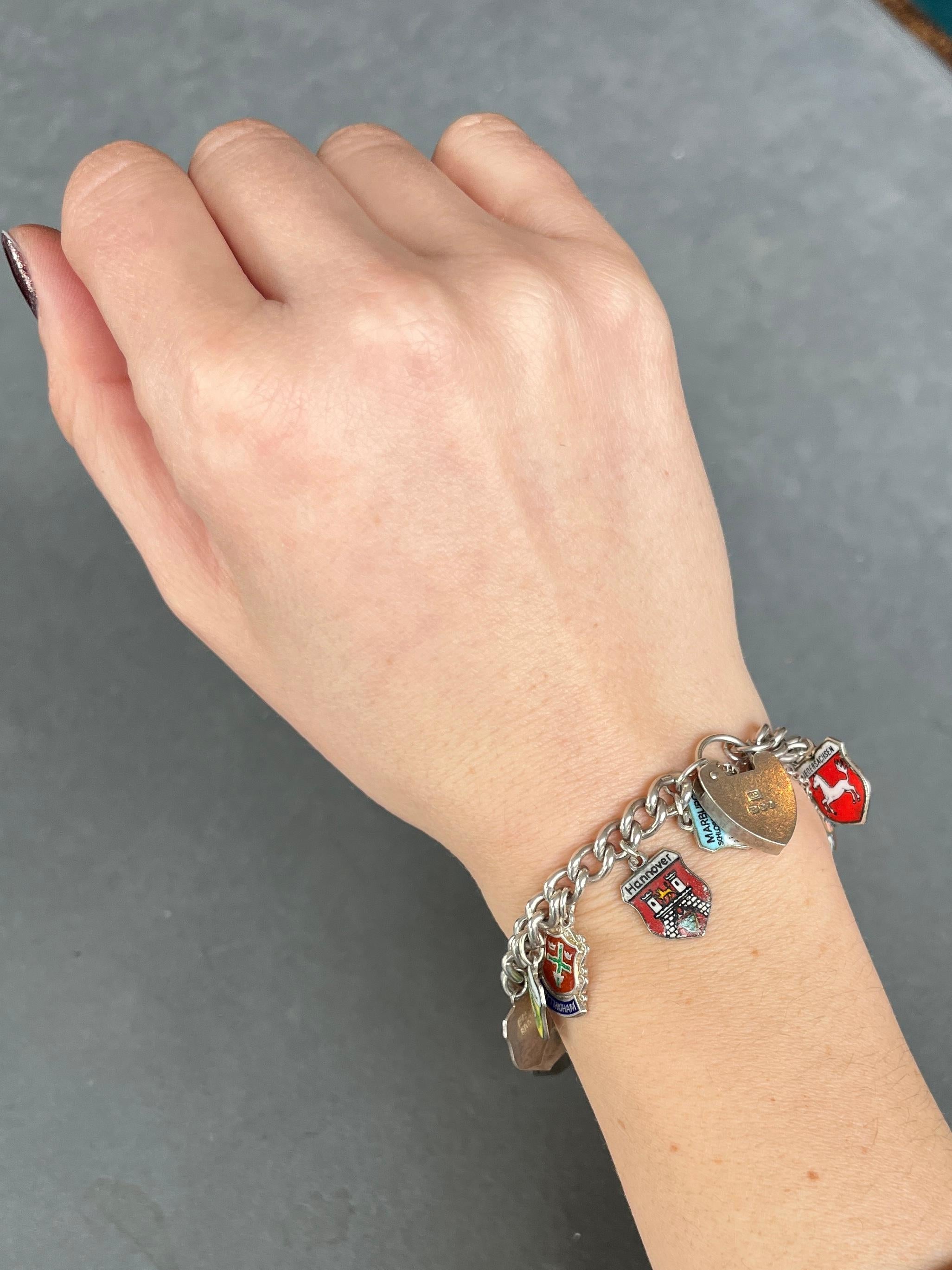 This classic silver corn bracelet has a silver padlock clasp which is hallmarked London. The charms are all city shields and there are 26 of them in total.

Length: 19cm 
Width: 6mm 

Weight: 48.8g