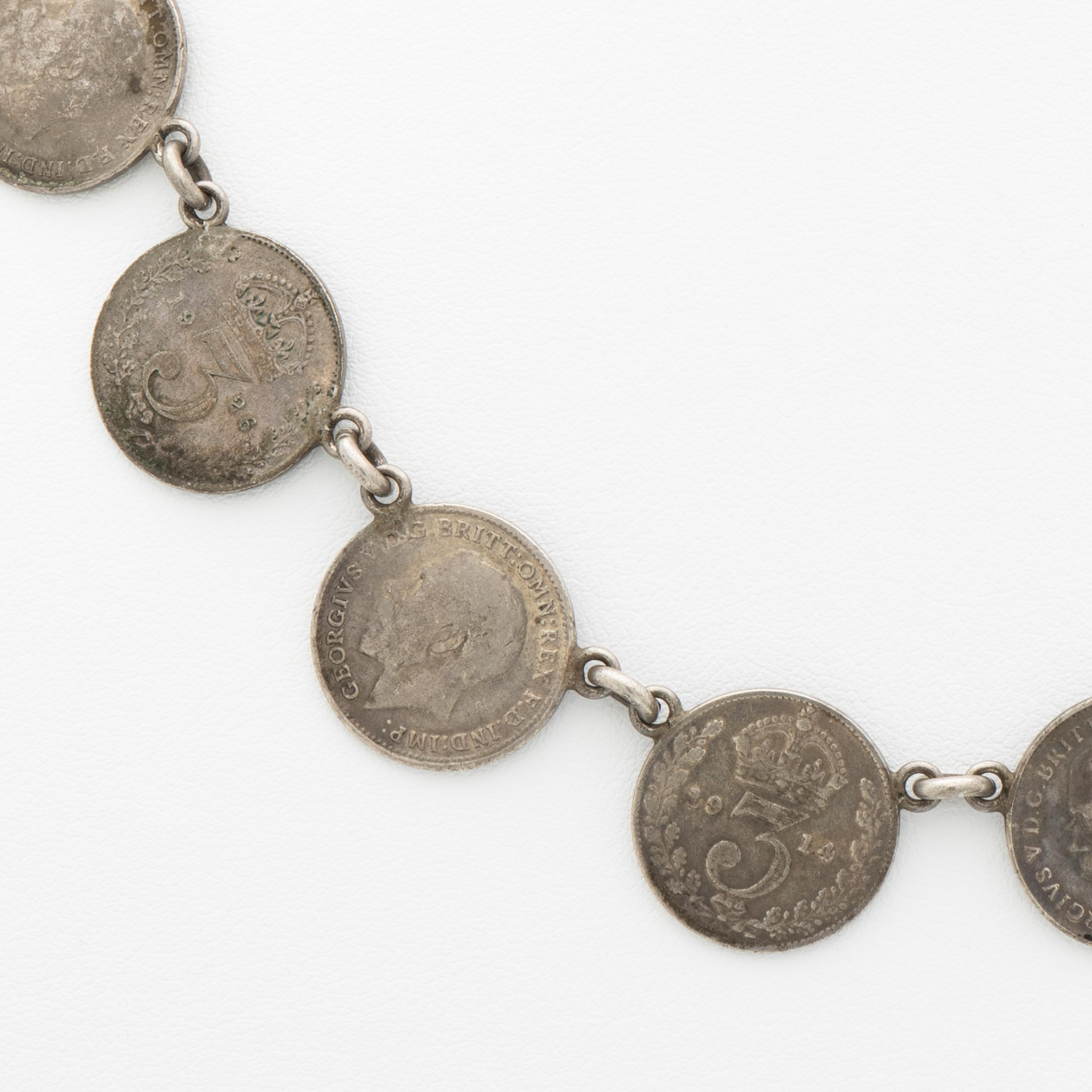 Antique Silver British Pence Coin Rivière c.1919

Length: 42.5cm / 16.73 in.
Width: 16.2mm / 0.64 in.
Weight: 32.68 grams

This antique silver necklace is unpolished and is oxidized but upon request we are happy to polish it for you.