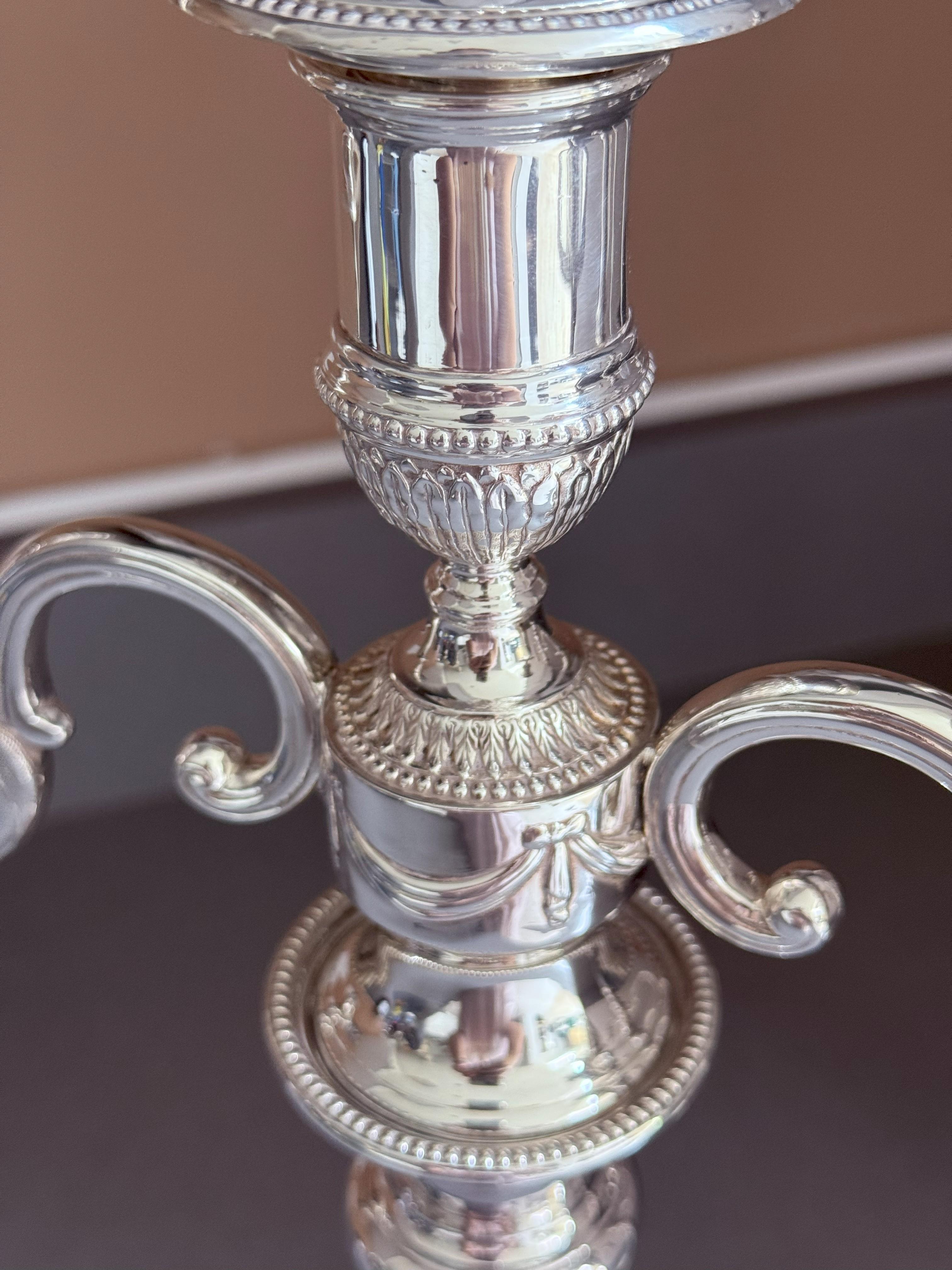 Un set di 2 portacandele, una coppia di eleganti e puri candelabri a tre luci in argento massiccio con marchio antico, di gusto tardo ottocentesco.
Questi raffinati candelabri hanno basi circolari sagomate e steli scanalati. Tutti gli ugelli sono