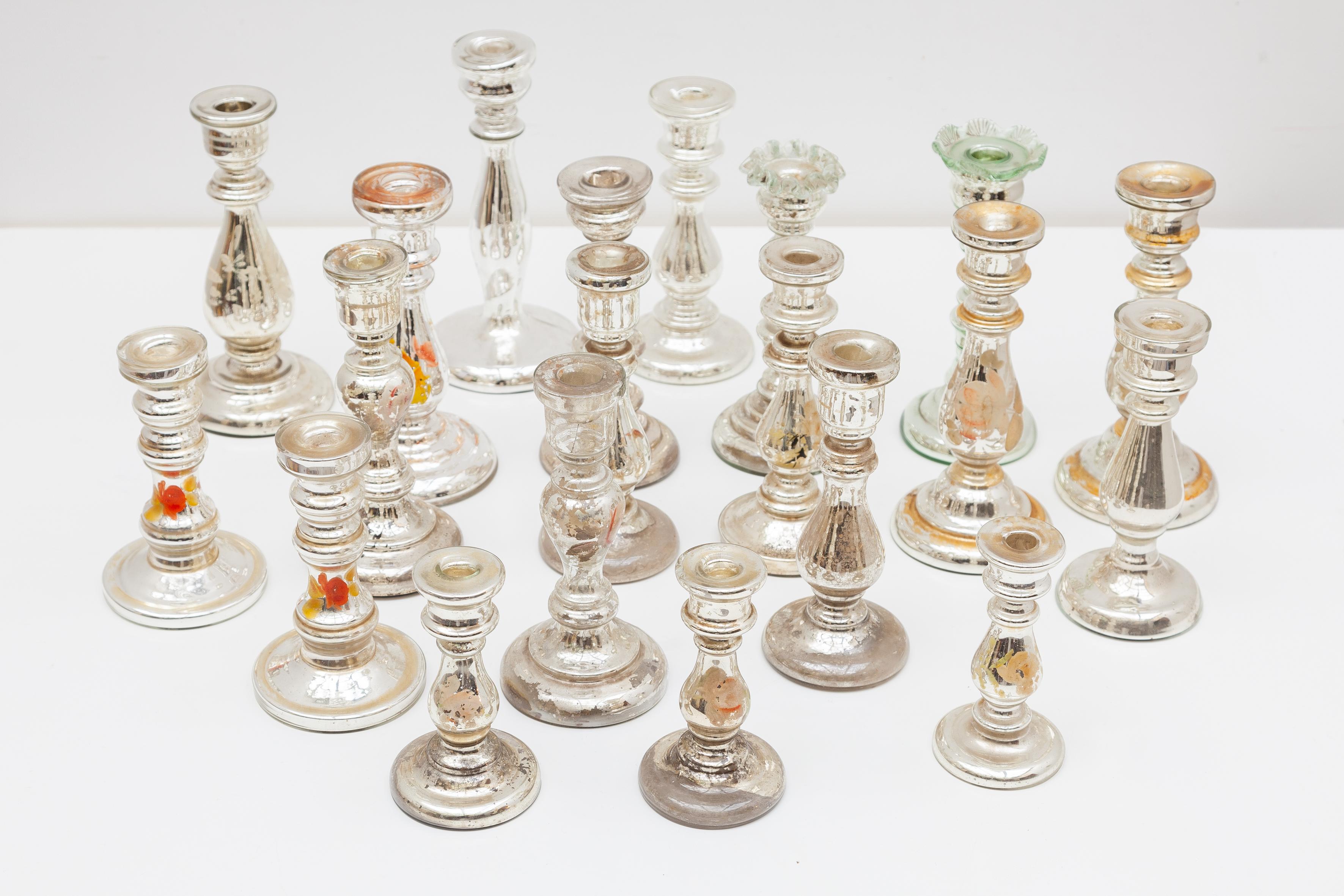 Un set di 20 varietà di candelabri in vetro specchiato Antique Mirror. L'interno dei candelabri è rifinito con una placcatura in argento che conferisce un aspetto brillante e sofisticato. Una grande collezione di candelieri soffiati a bocca e