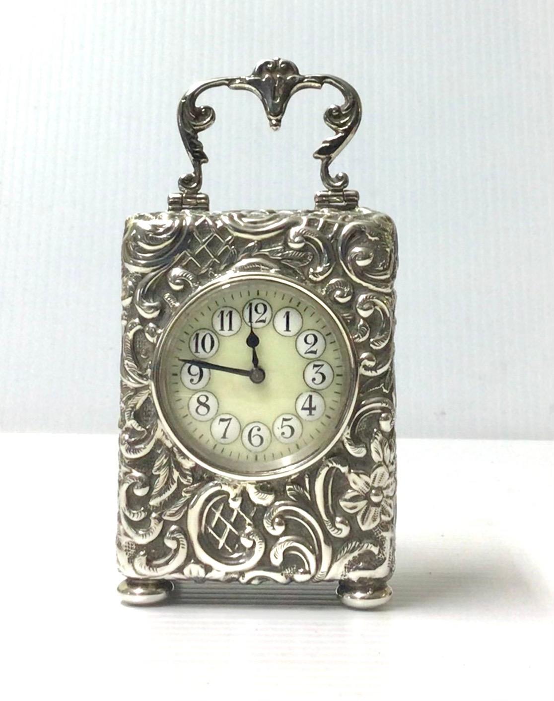 Lovely beautifully chased, diminutive, antique silver carriage clock, dated 1924, hallmarked for Henry Matthews, Birmingham, the round porcelain dial with arabic numerals on convex roundels, 8 day movement professionally serviced and guaranteed for