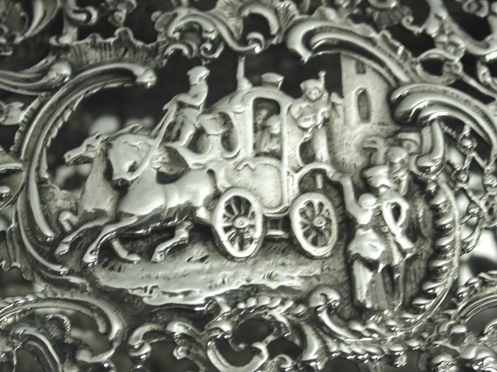 Antique silver cast and pierced trinket box, dated 1902, London Assay, William Comyns
The scene on the top of the box looks very much like a wedding couple leaving for their honeymoon.
This maker specialized in beautifully adorned heavy embossed