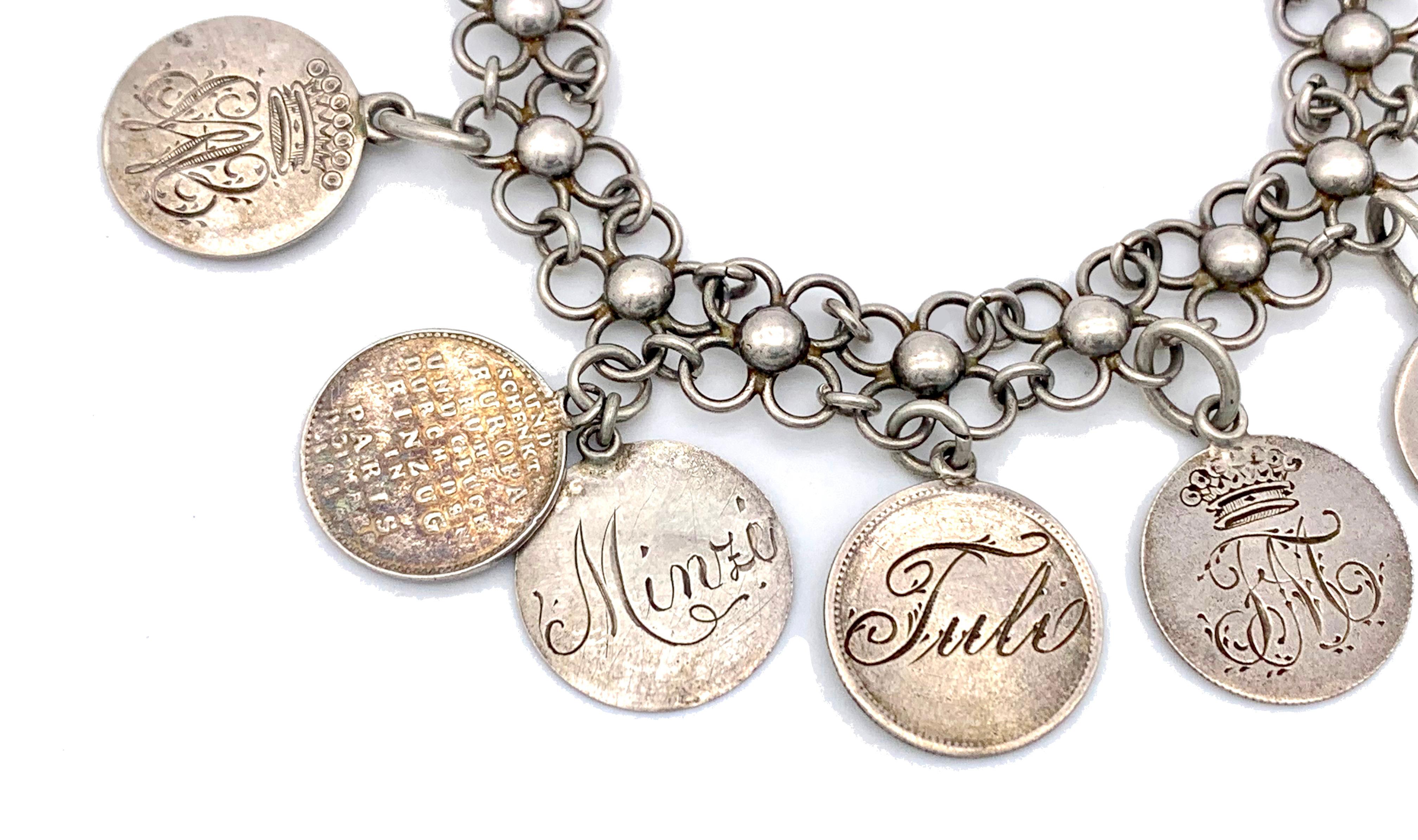 Questo bracciale a maglie flessibili in argento è disegnato come sedici fiori d'argento collegati da maglie d'argento. Dodici tondi tondi  Al bracciale sono attaccati undici ciondoli in argento, mentre il ciondolo con il papa è in metallo placcato