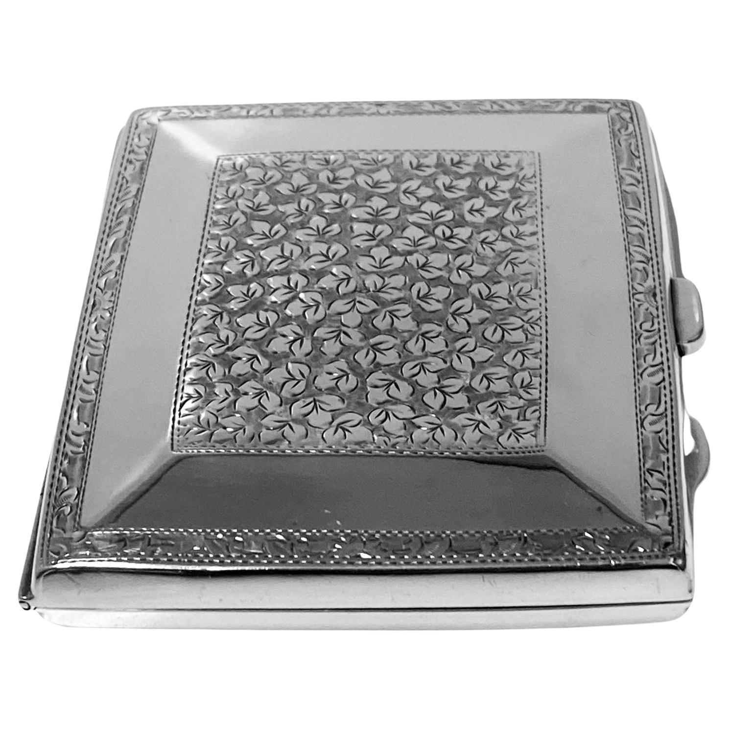 English Silver Cigarette Case Birmingham 1911, Joseph Gloster Ltd. Slightly concave rectangular shape case;  front, reverse and outside border with engraved central panel decoration, plain polished silver inner border margin. Vacant shield to front.