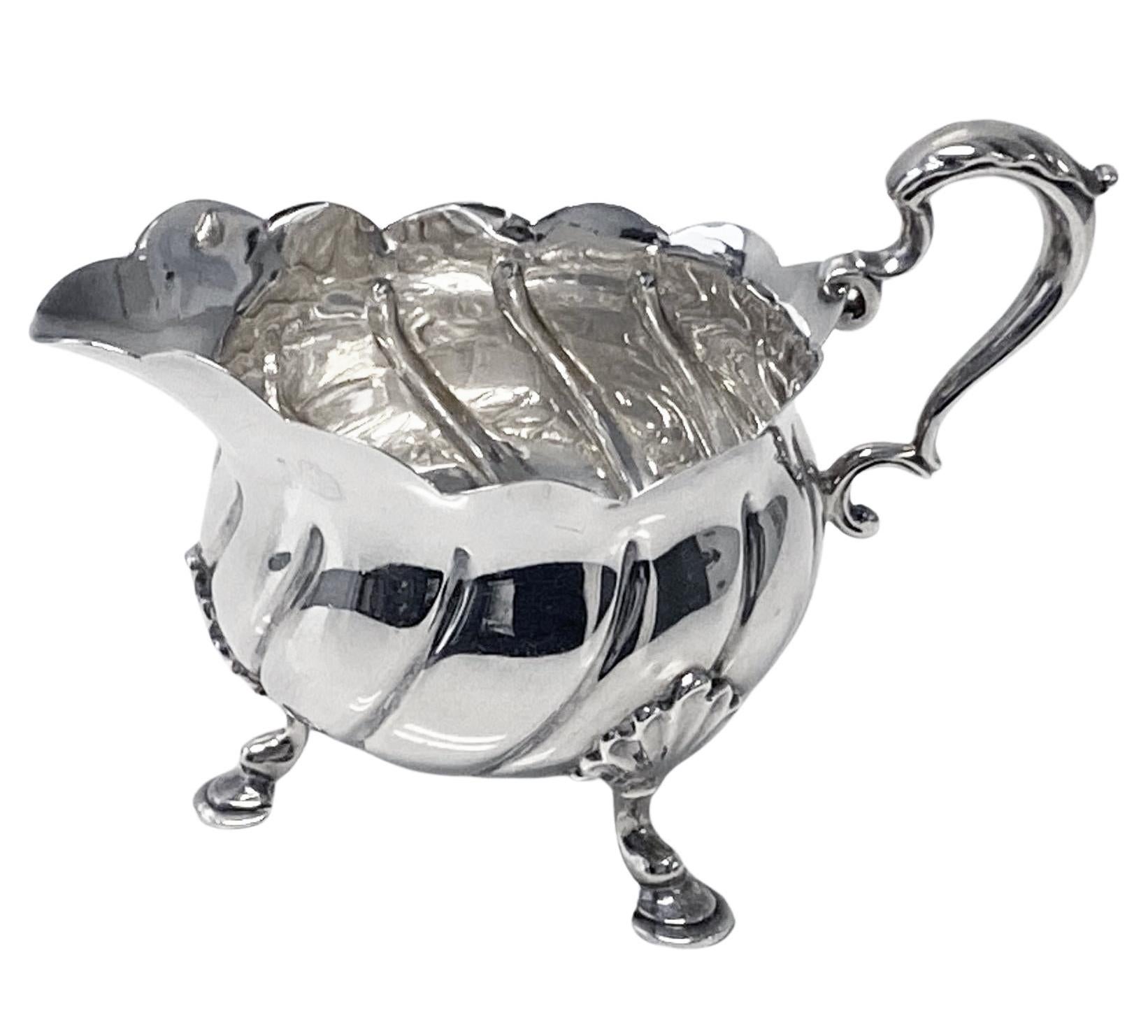 Antique Silver Cream Jug London 1899 Messrs Barnard. The jug on on three shell knuckle mask feet, swirl design surround body, scalloped everted rim, acanthus foliate capped double scroll handle. Handle to spout : 4.25 inches. Width: 2.50 inches.
