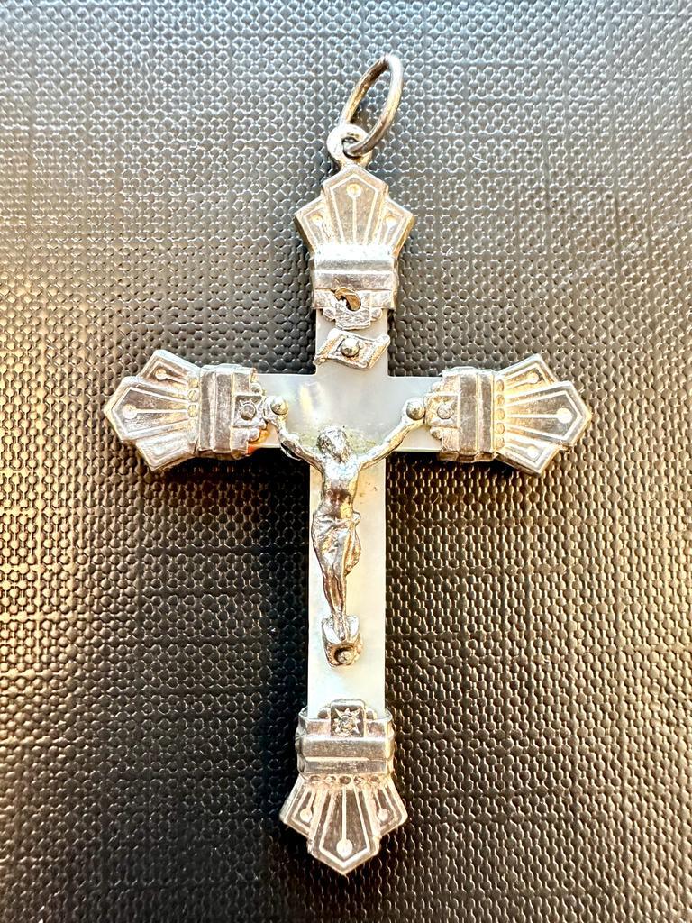 This ancient crucifix is made entirely in mother of pearl. The decorations and ends of the pendant are handcrafted in 925 silver. Being very old, the silver is not rhodium plated giving it a matified look. This silver crucifix is in good used