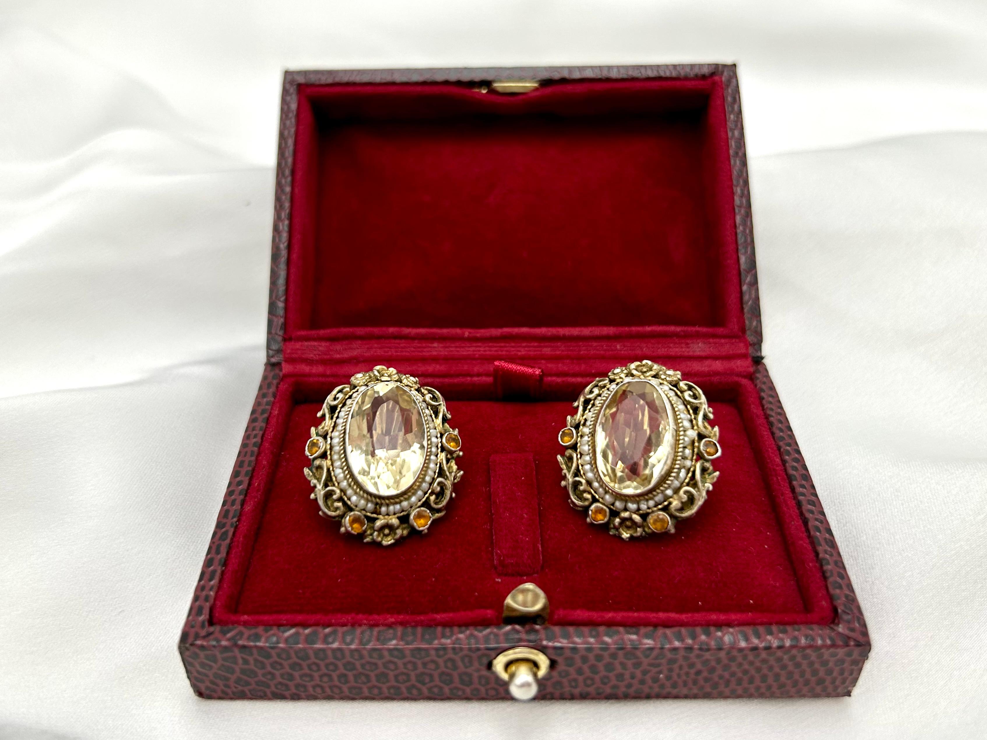 Alte Silberohrringe mit Goldspangen mit Zitrinen, Perlen und Granaten aus der Zeit um 1900.

Ohrringe aus 0,900er Sterlingsilber; Goldspangen (wahrscheinlich Mitte des 20. Jahrhunderts in Schweden umgearbeitet) mit einem Goldfeingehalt von