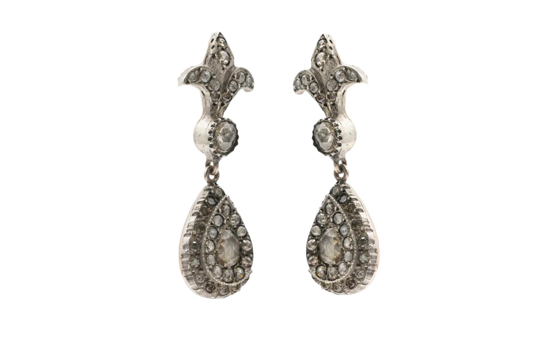 Antike Ohrringe, besetzt mit Diamanten in Form von alten Rosetten. Eine wunderschöne Komposition mit einem französischen Fleur-de-lis-Motiv (ein Synonym für französische Eleganz, Aristokratie und Prestige).

Die Ohrringe sind aus 0,900-0,950er