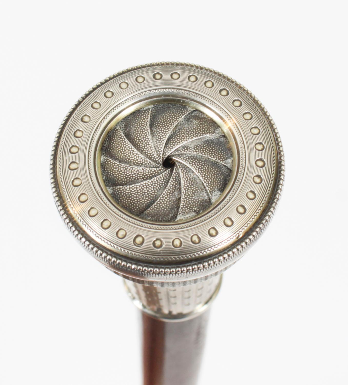 This is a beautiful and distinctive antique Gentlemans ebonised gadget walking stick with an exquisite silver watch fashioned into the handle which bears Swiss silver hallmarks.

The ornate decorative engine turned Swiss silver pommel containing a