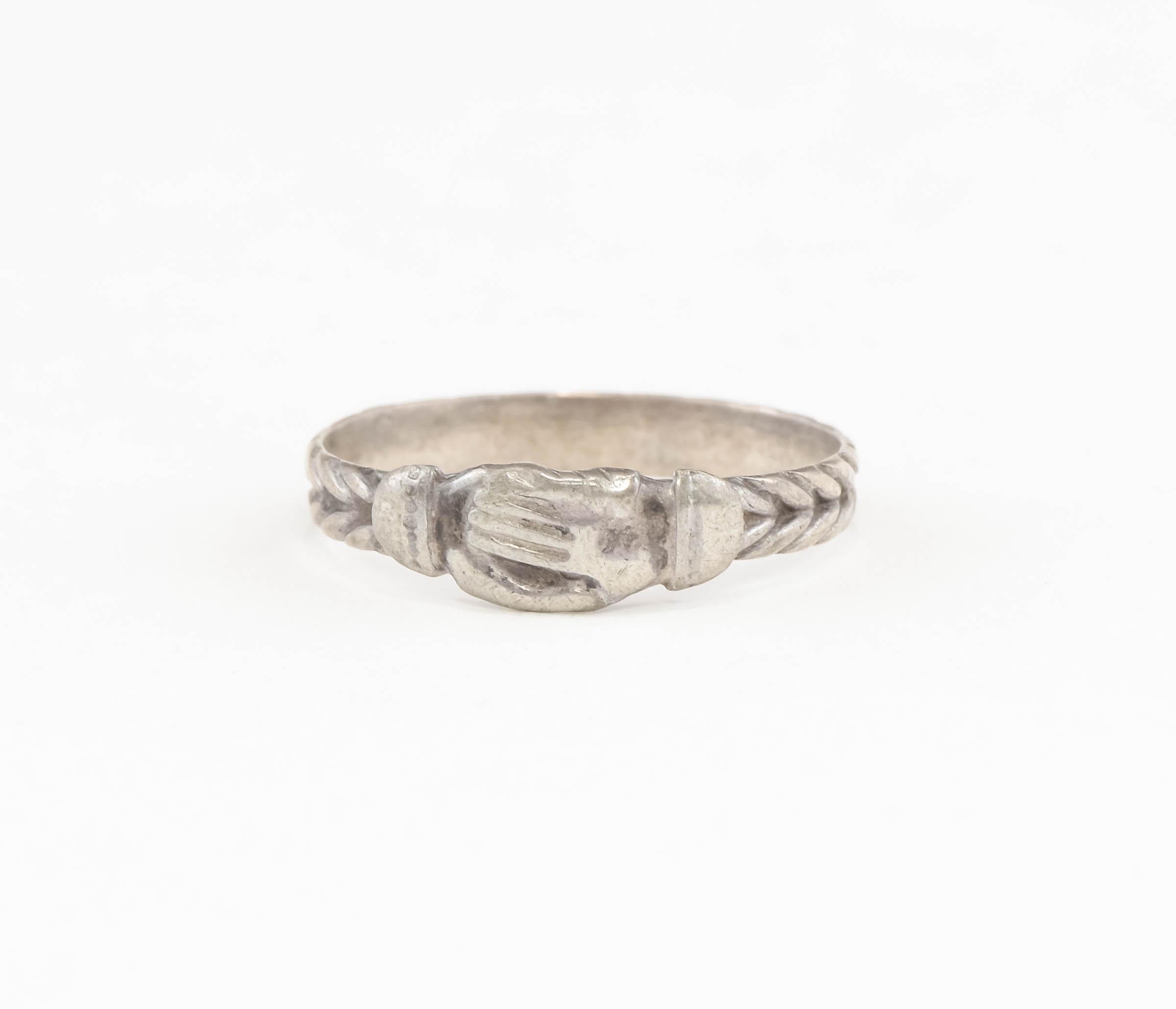J'ai le plaisir de vous proposer une charmante et particulière bague ancienne Fede de Bretagne.

Fabriquée en argent proche de la norme Sterling, cette bague présente le motif classique des mains jointes symbolisant l'amour, l'amitié et les